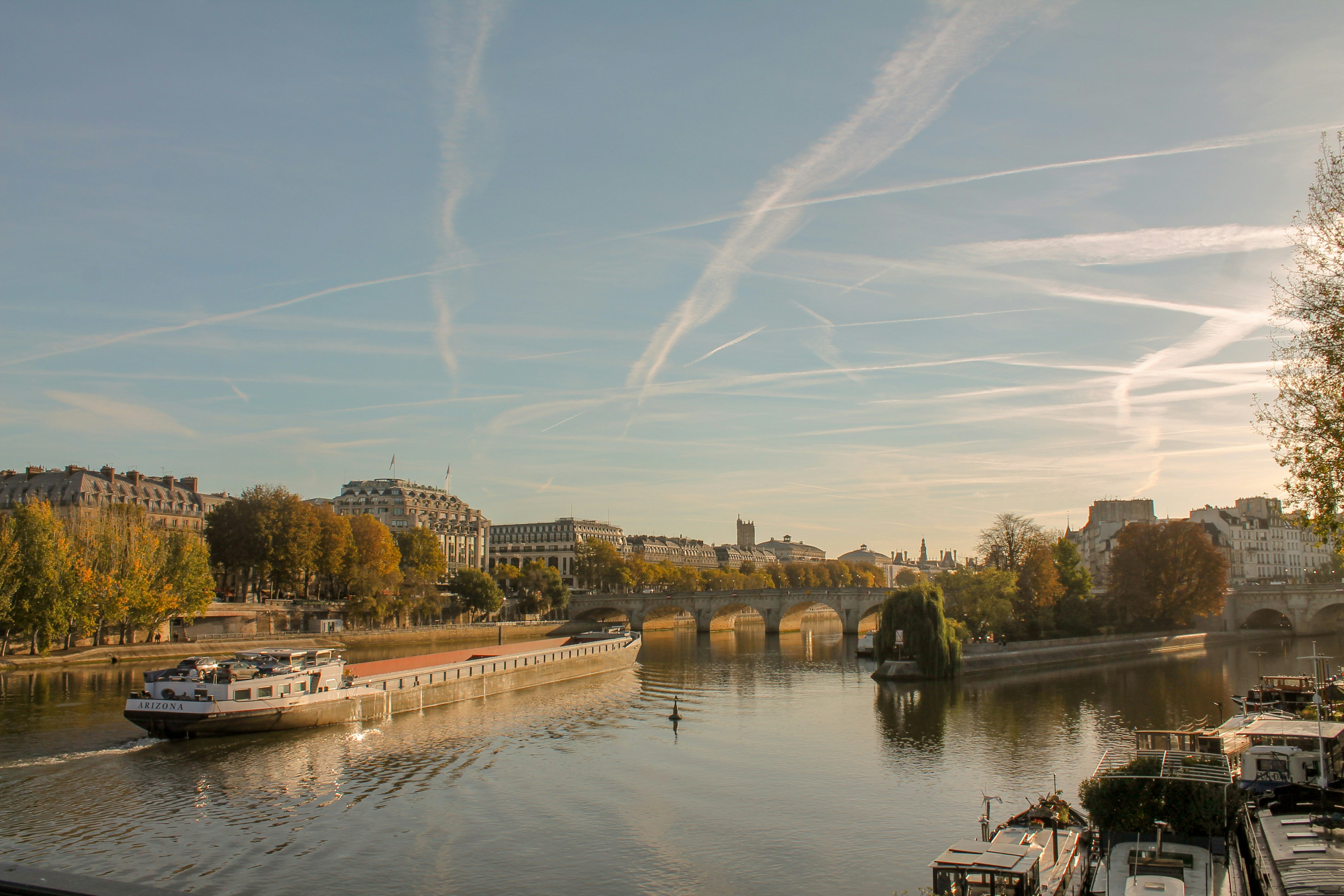 A river with boats on it and a bridge in the background