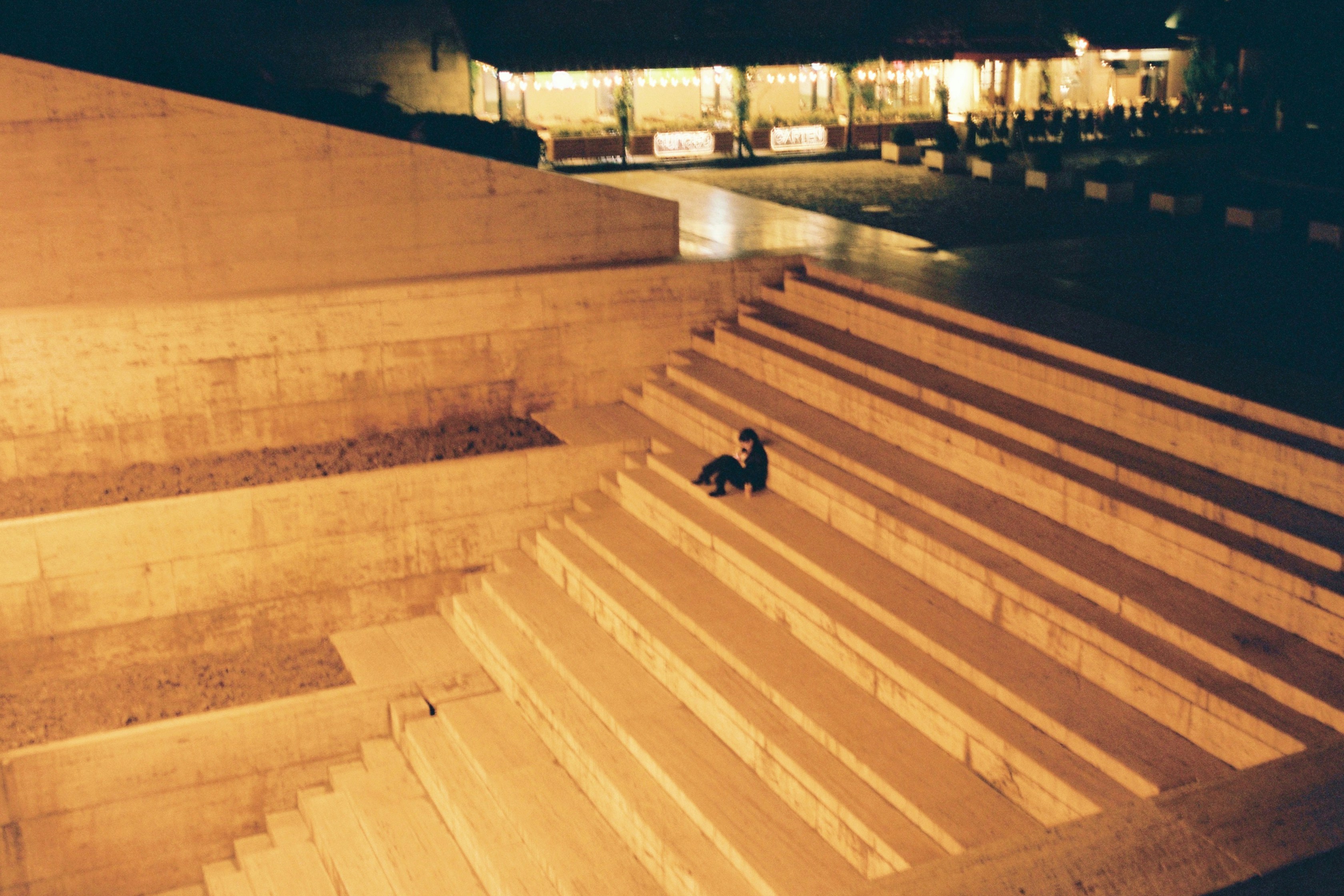 A person seen from a low angle taking a decisive step up a set of modern, architectural stairs, symbolizing the first step into a future with artificial intelligence.