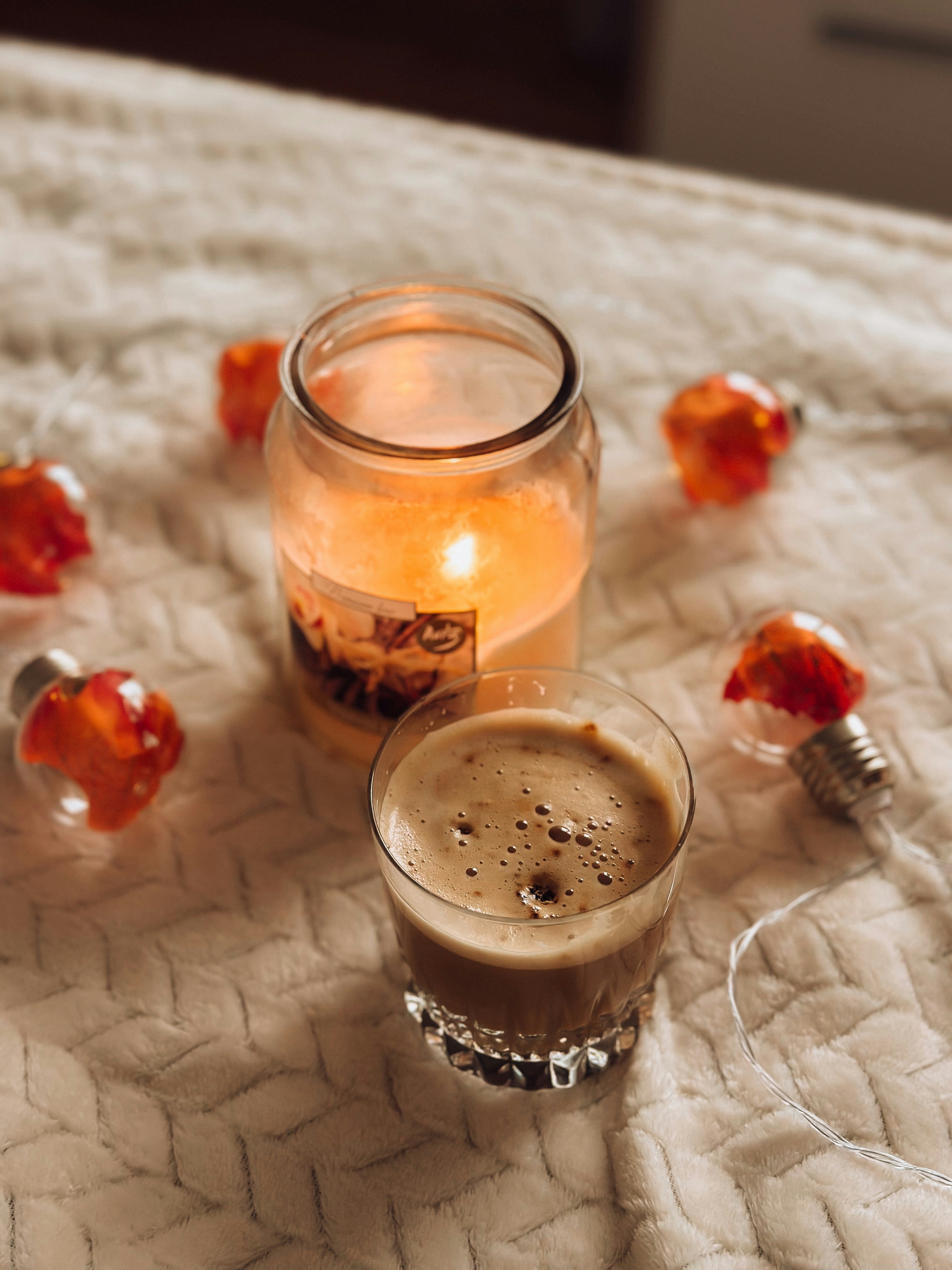 Un bicchiere di birra seduto sopra un letto