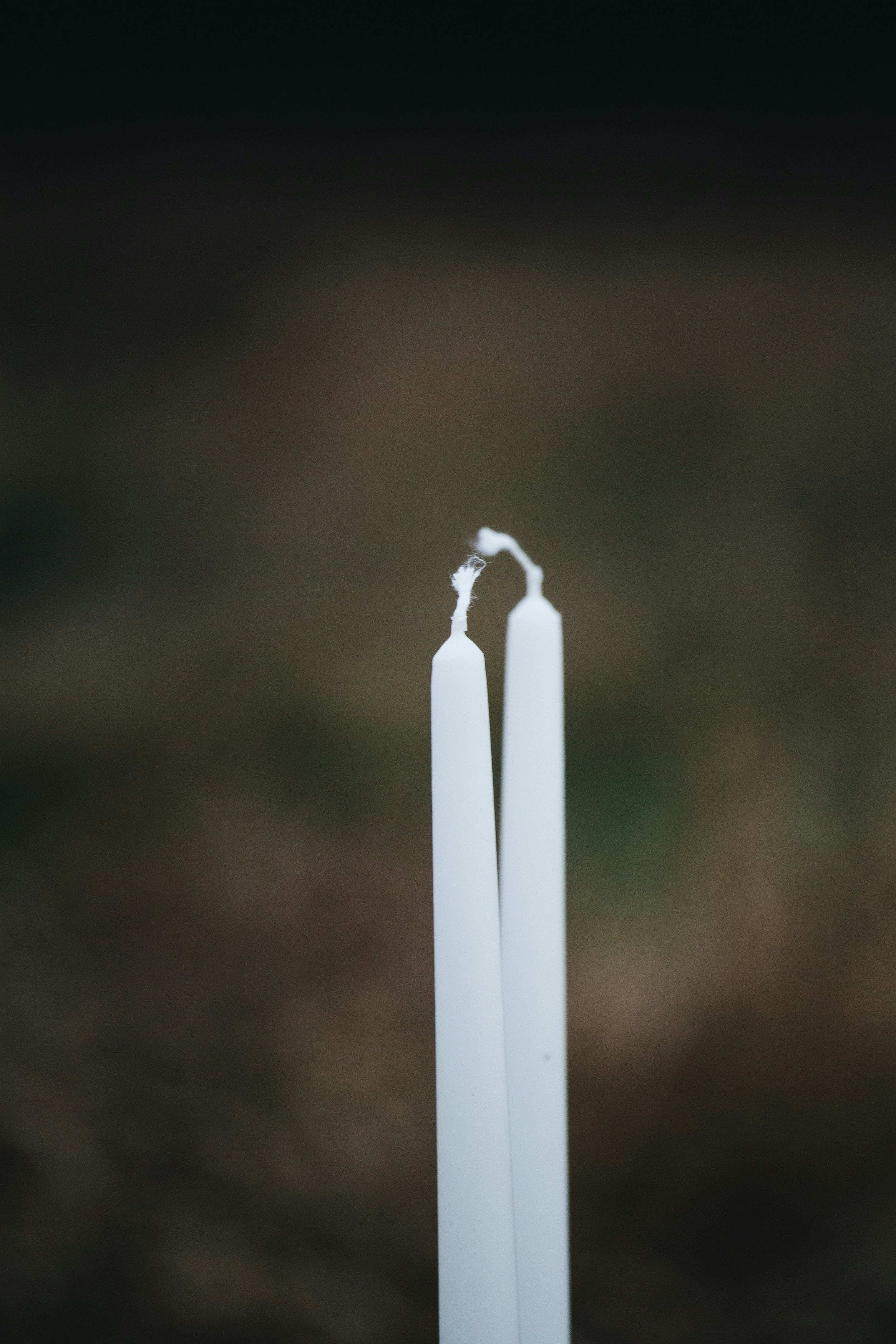 Un par de velas blancas encima de una mesa