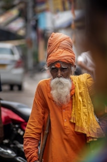 A man with a white beard wearing an orange turban