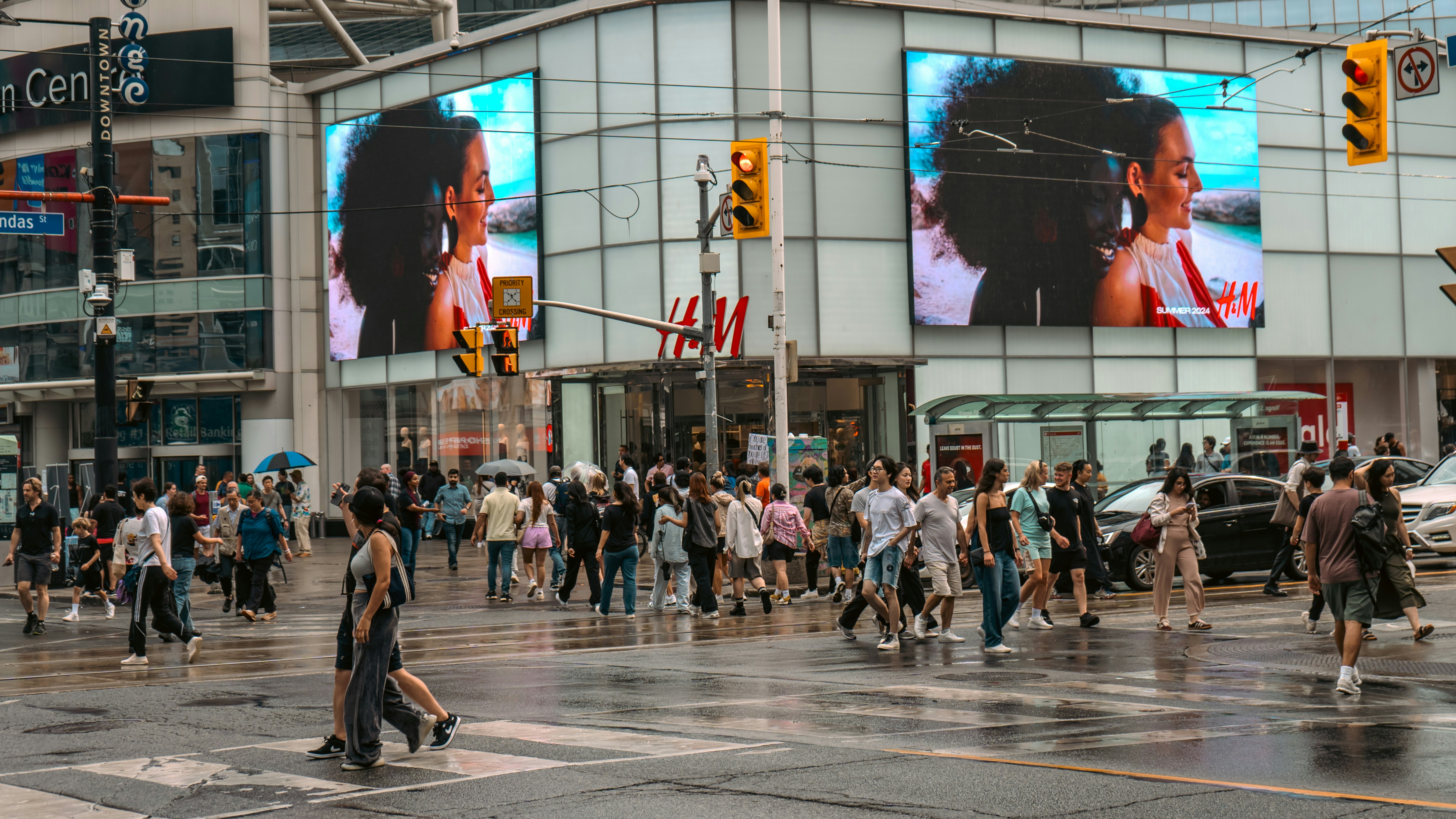 A crowd of people crossing a street in front of a building