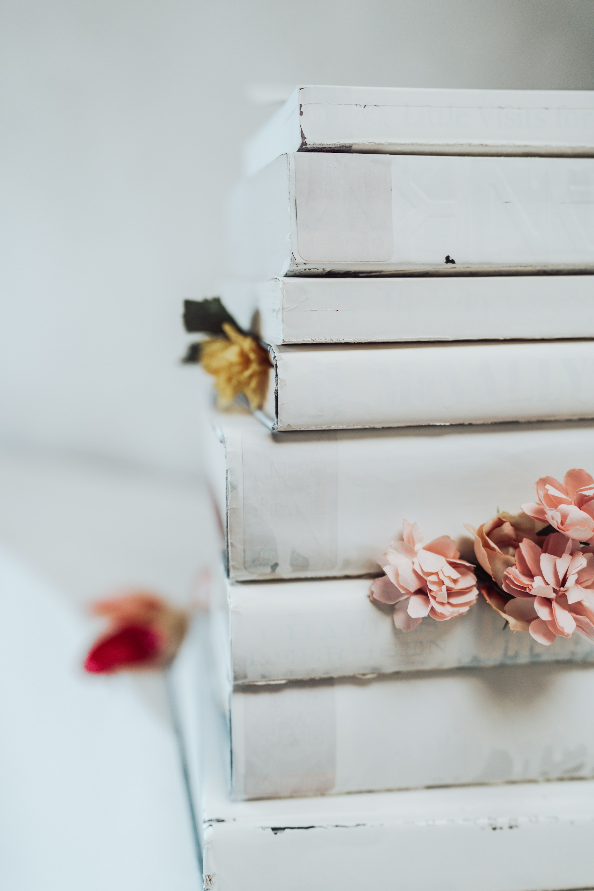 A stack of white books with pink flowers on them