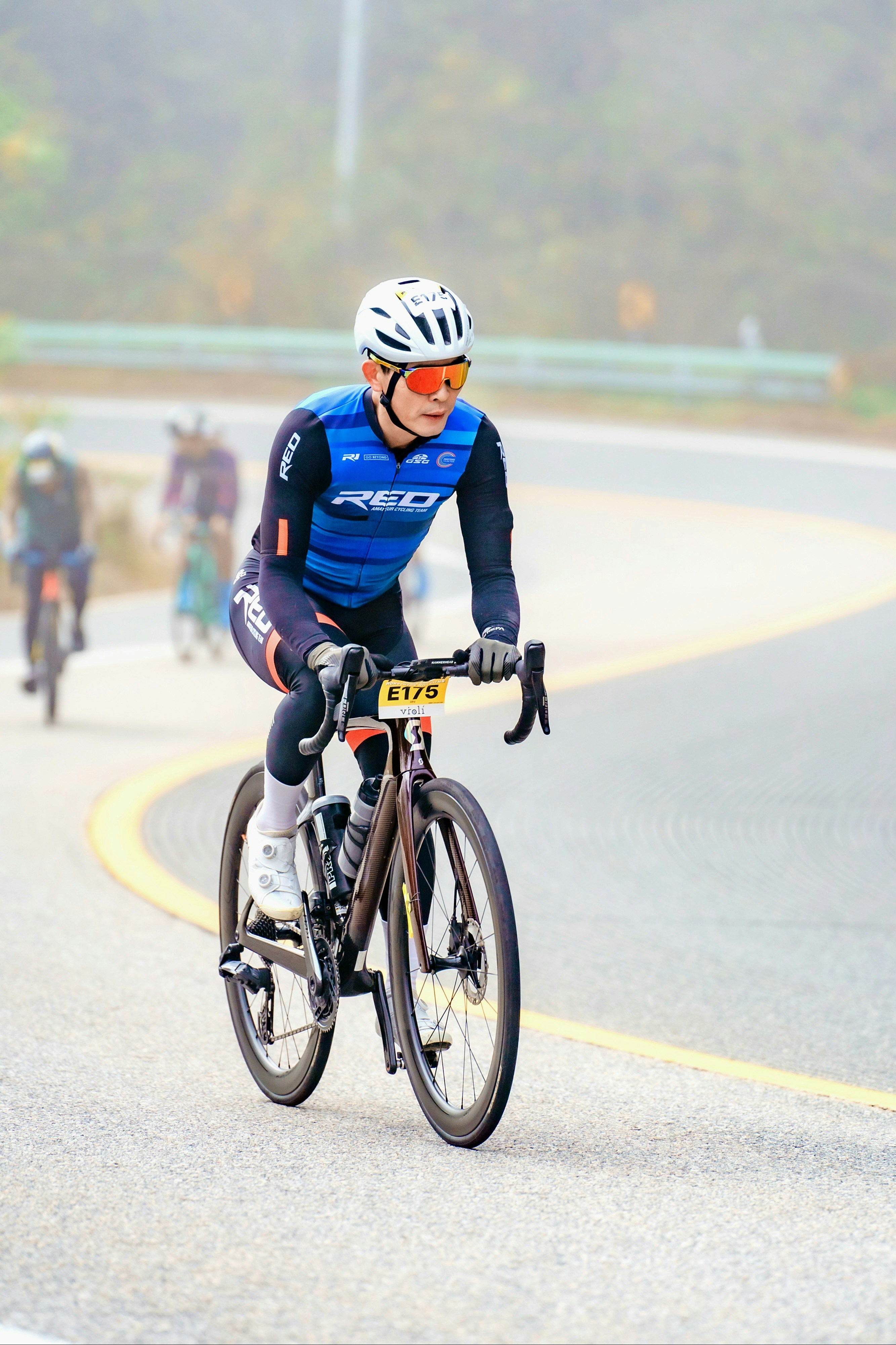Um homem andando de bicicleta por uma estrada sinuosa