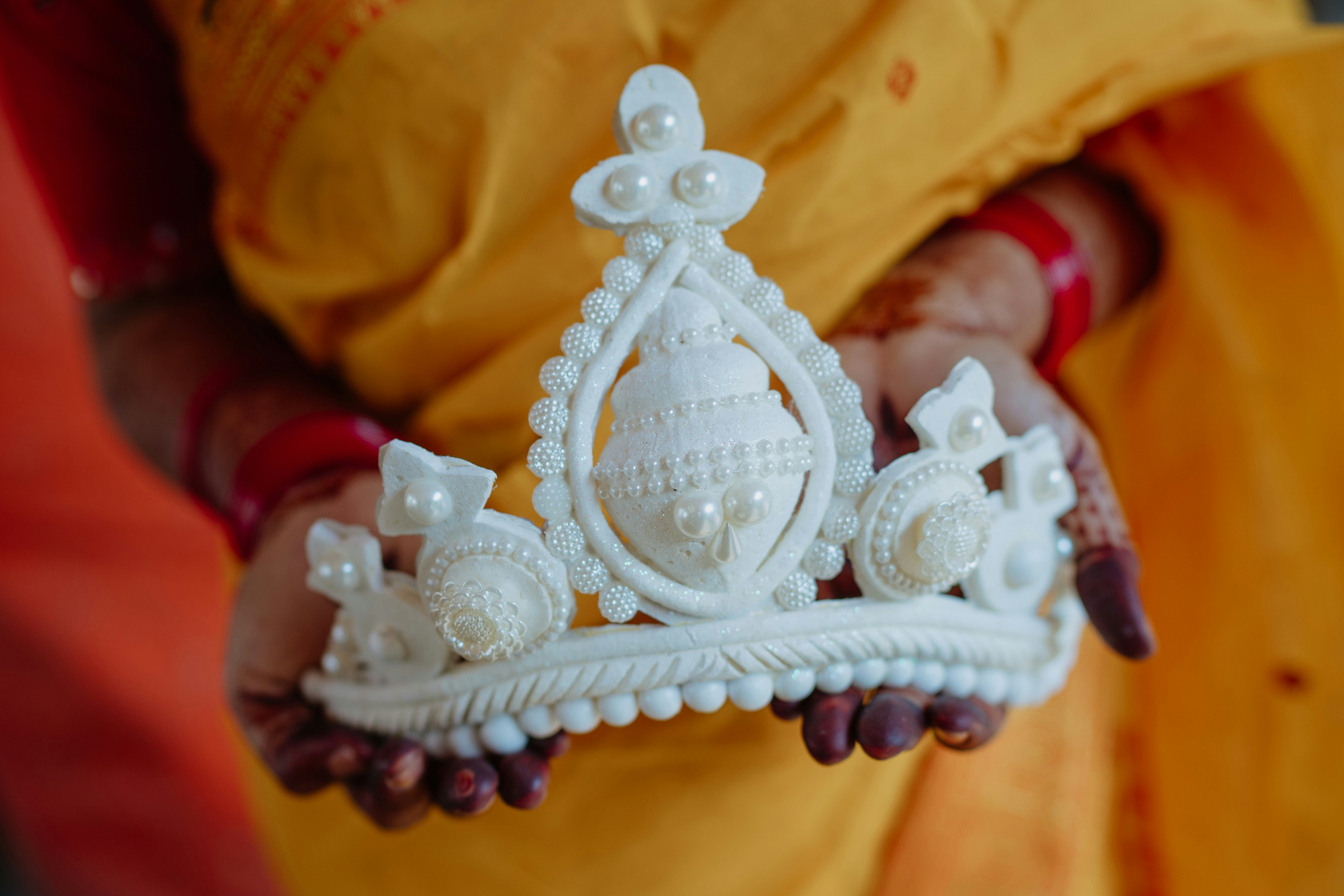 A person holding a white crown in their hands