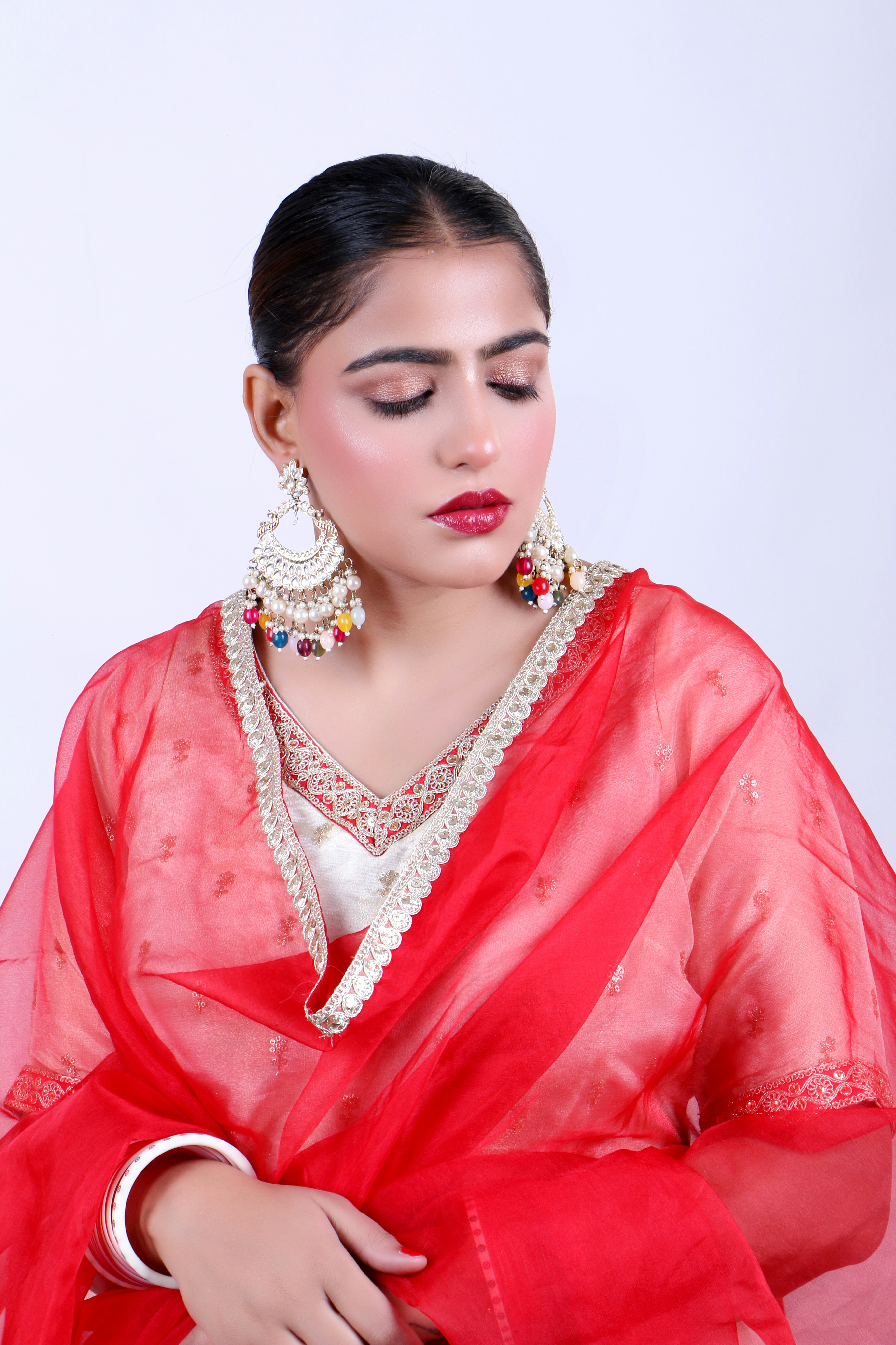 A woman wearing a red sari and jewelry