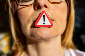 A woman with a red and white warning sign on her nose