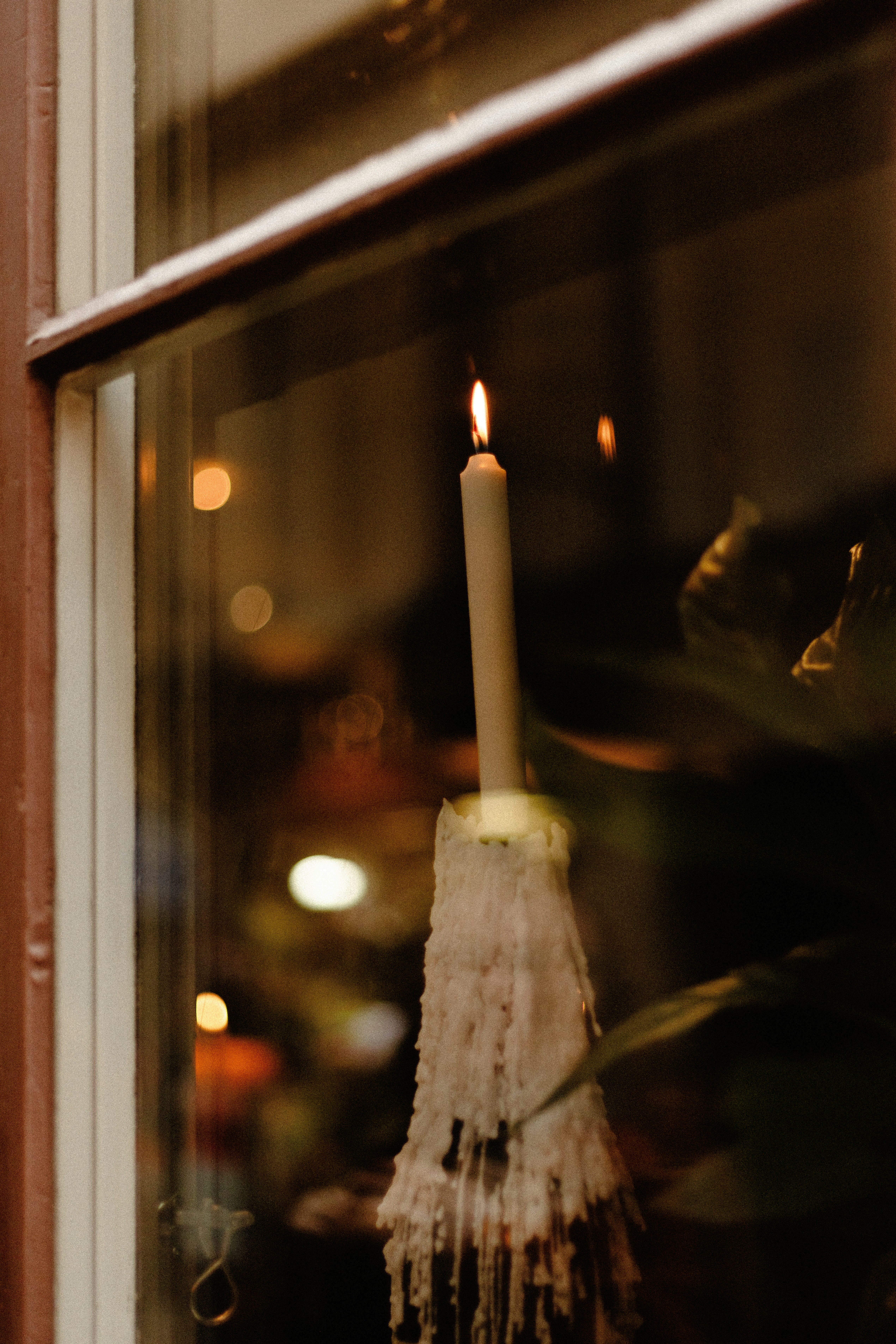 A lit candle sitting in a window sill