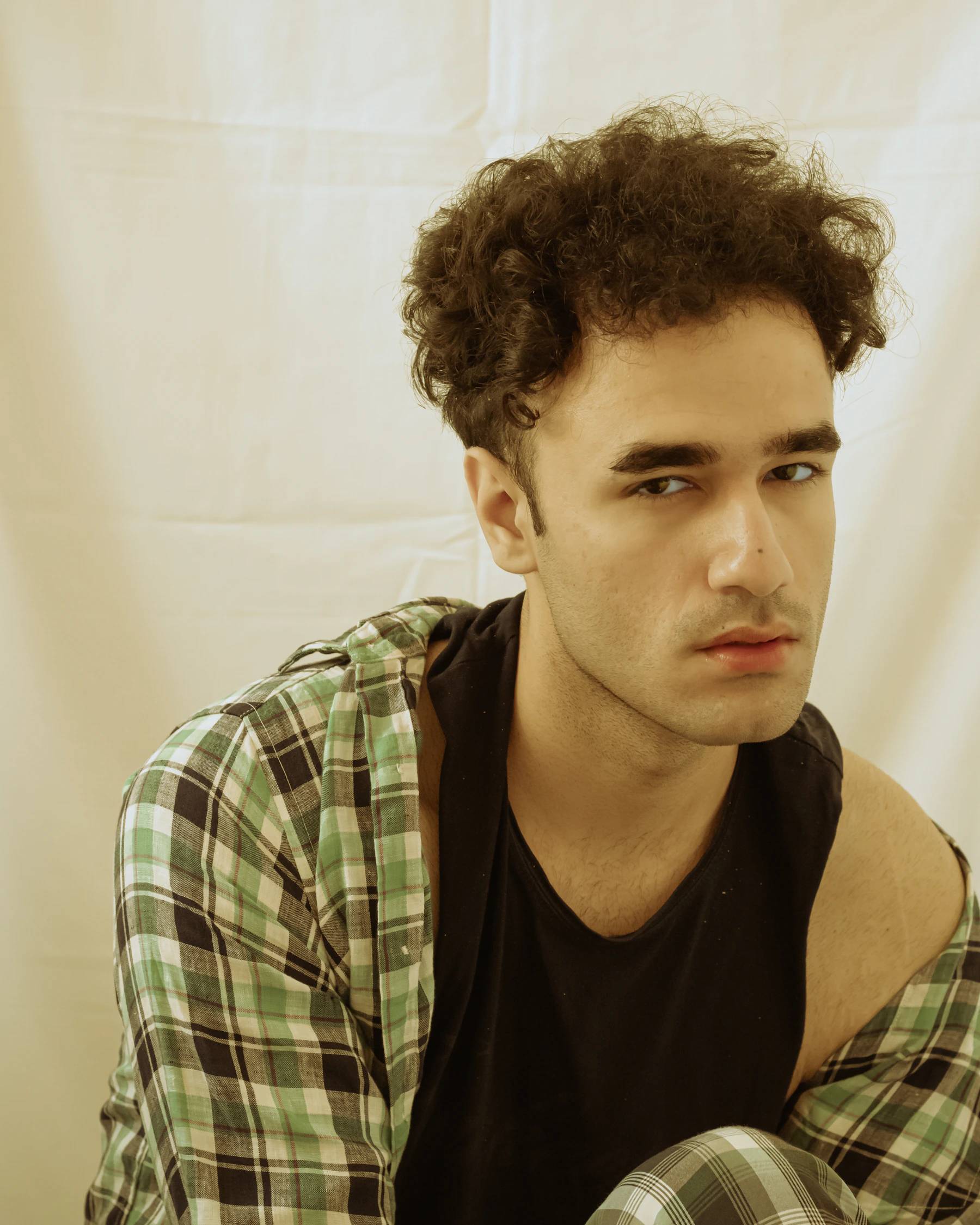 Editorial portrait of a man with defined, textured curly hair
