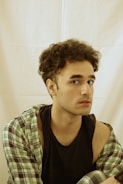 A man with curly hair and a black shirt