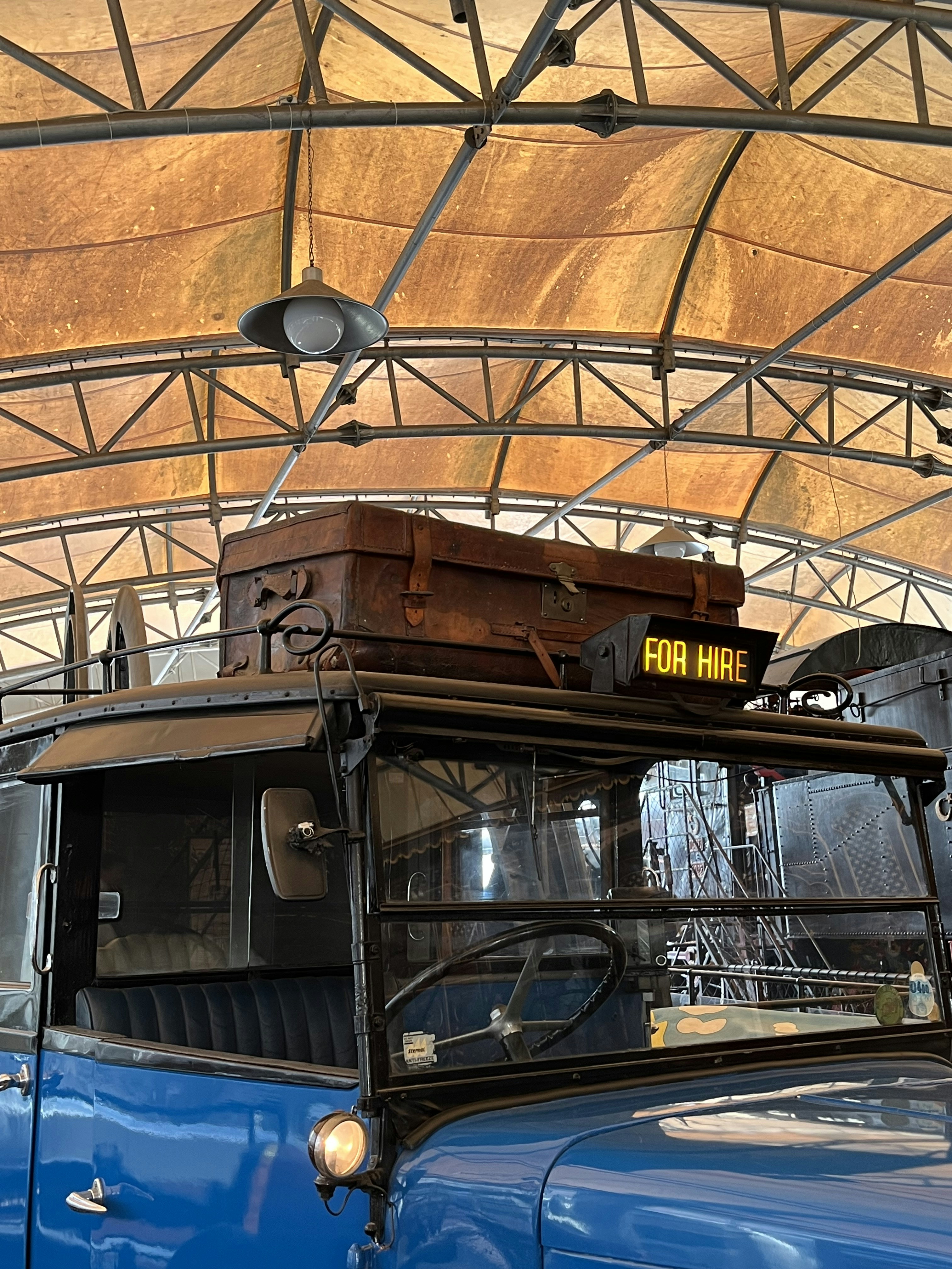 Sebuah truk biru tua berada di bawah kanopi