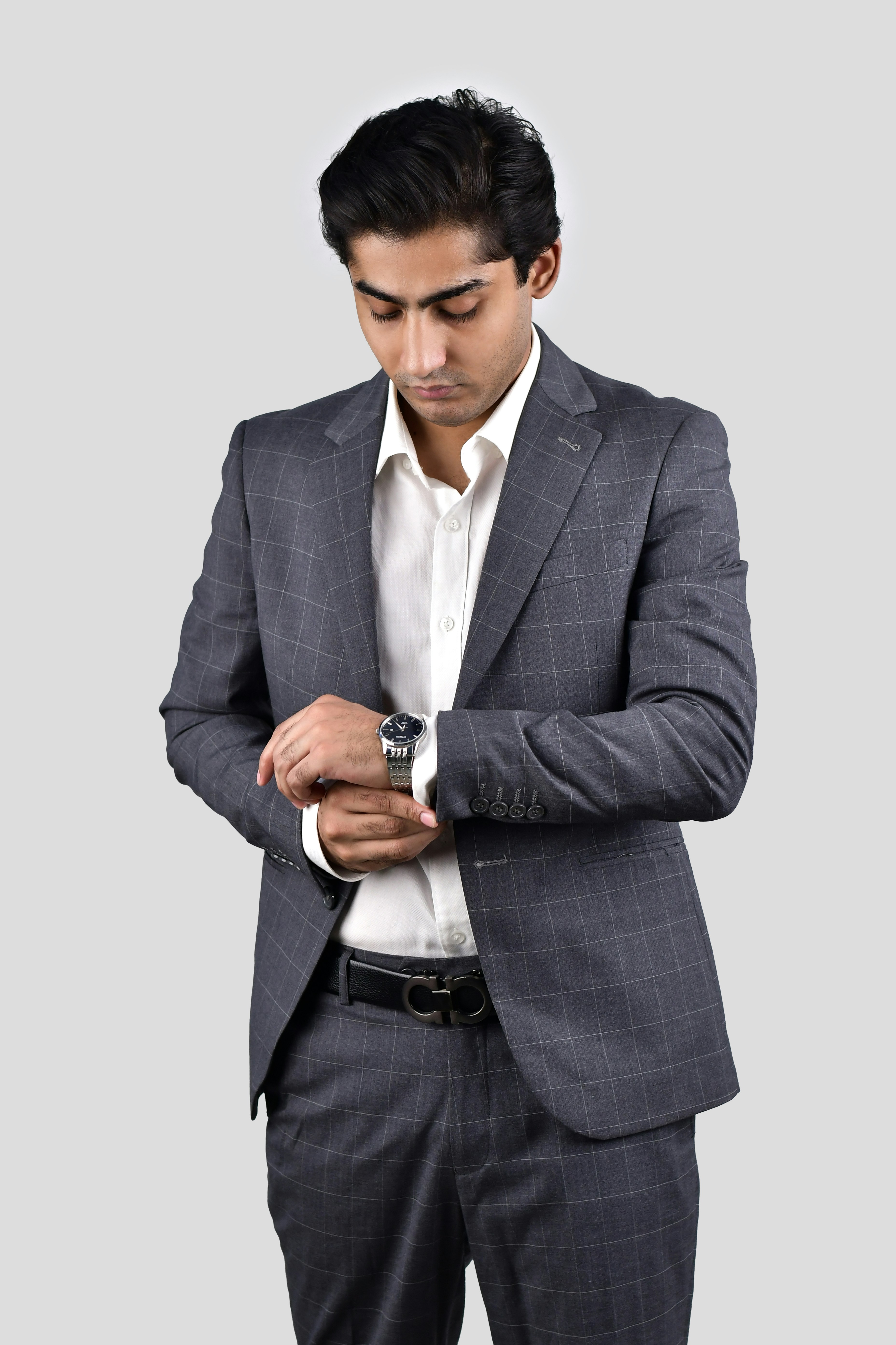 A man in a suit looking down at his watch