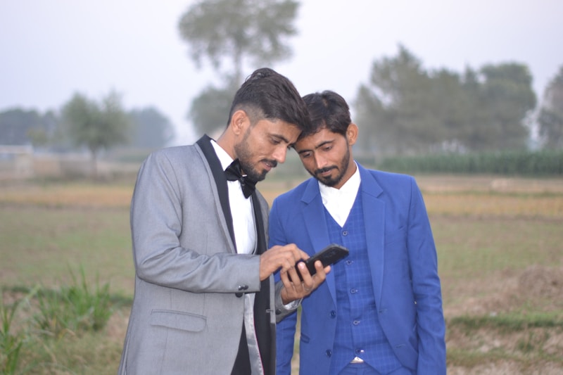 Suited men checking phone together