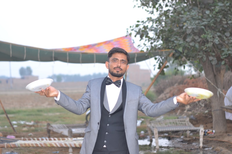 A man in a tuxedo holding a frisbee