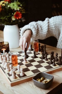 A woman playing a game of chess on a table