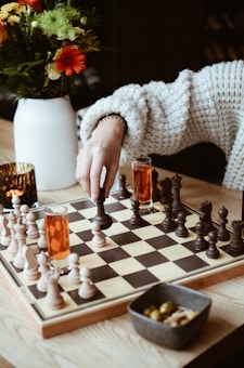 A woman playing a game of chess on a table