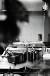 A person in a kitchen preparing food on a stove