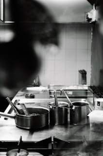 A person in a kitchen preparing food on a stove