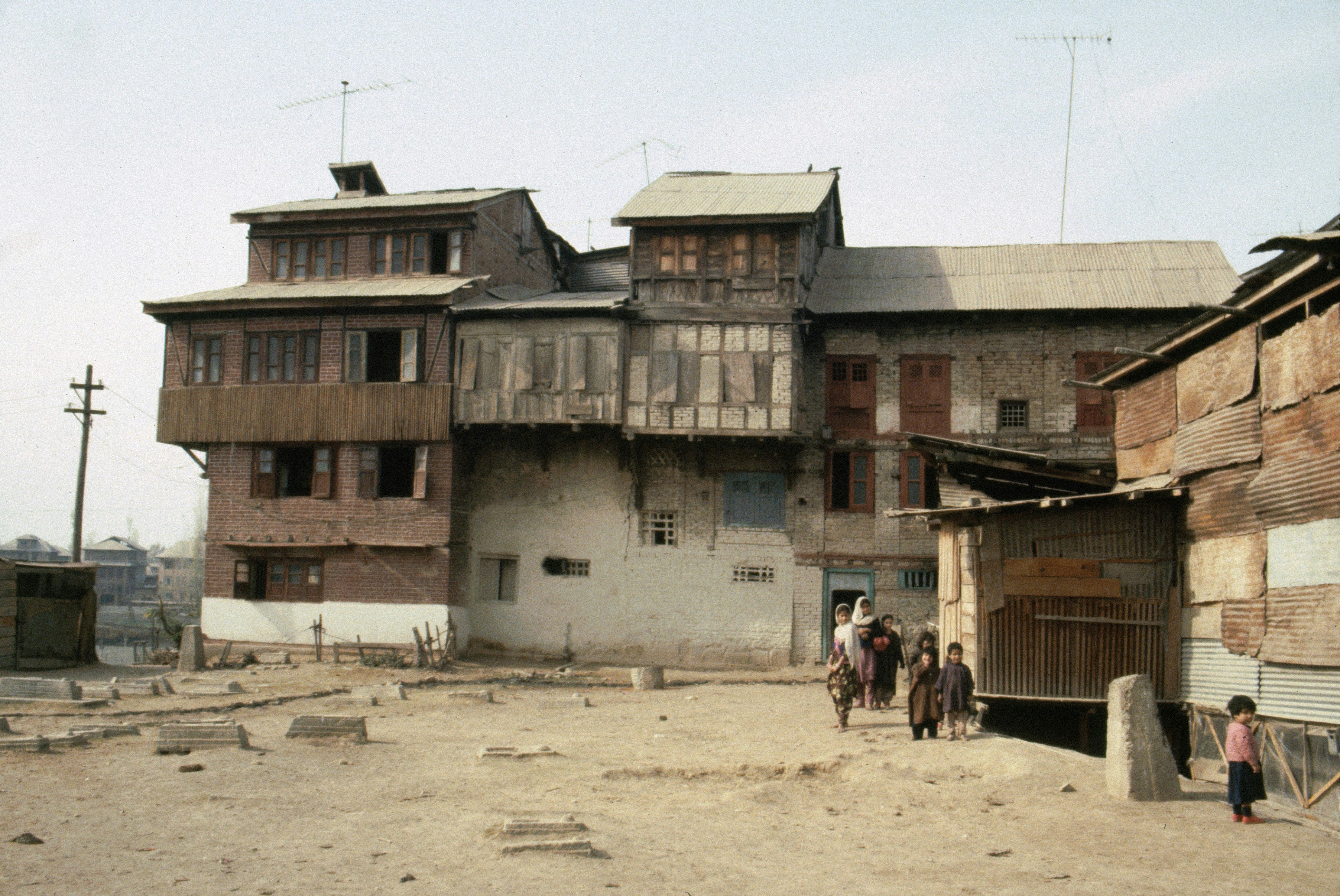Old wooden buildings with people walking in courtyard.