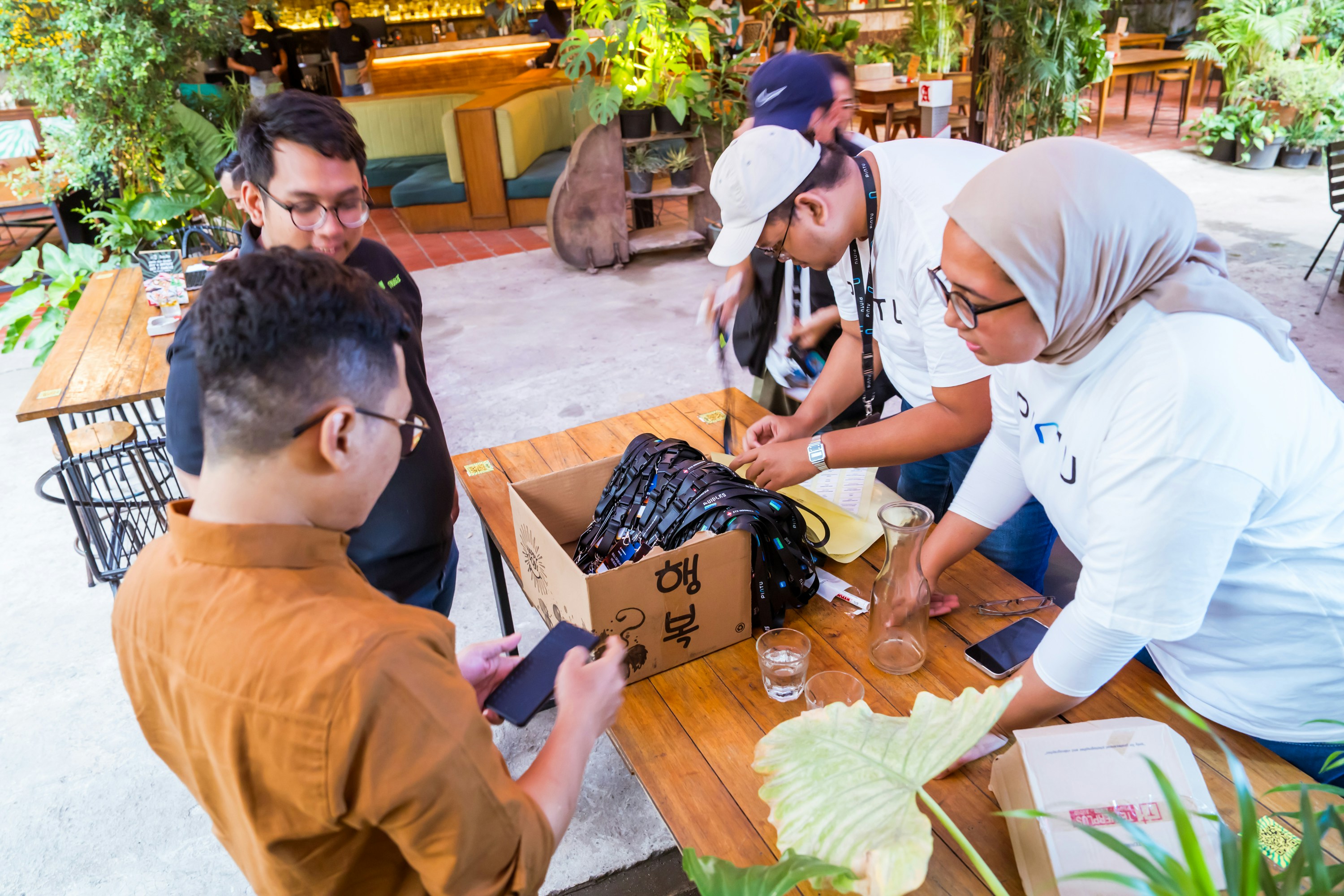 A group of people standing around a wooden table