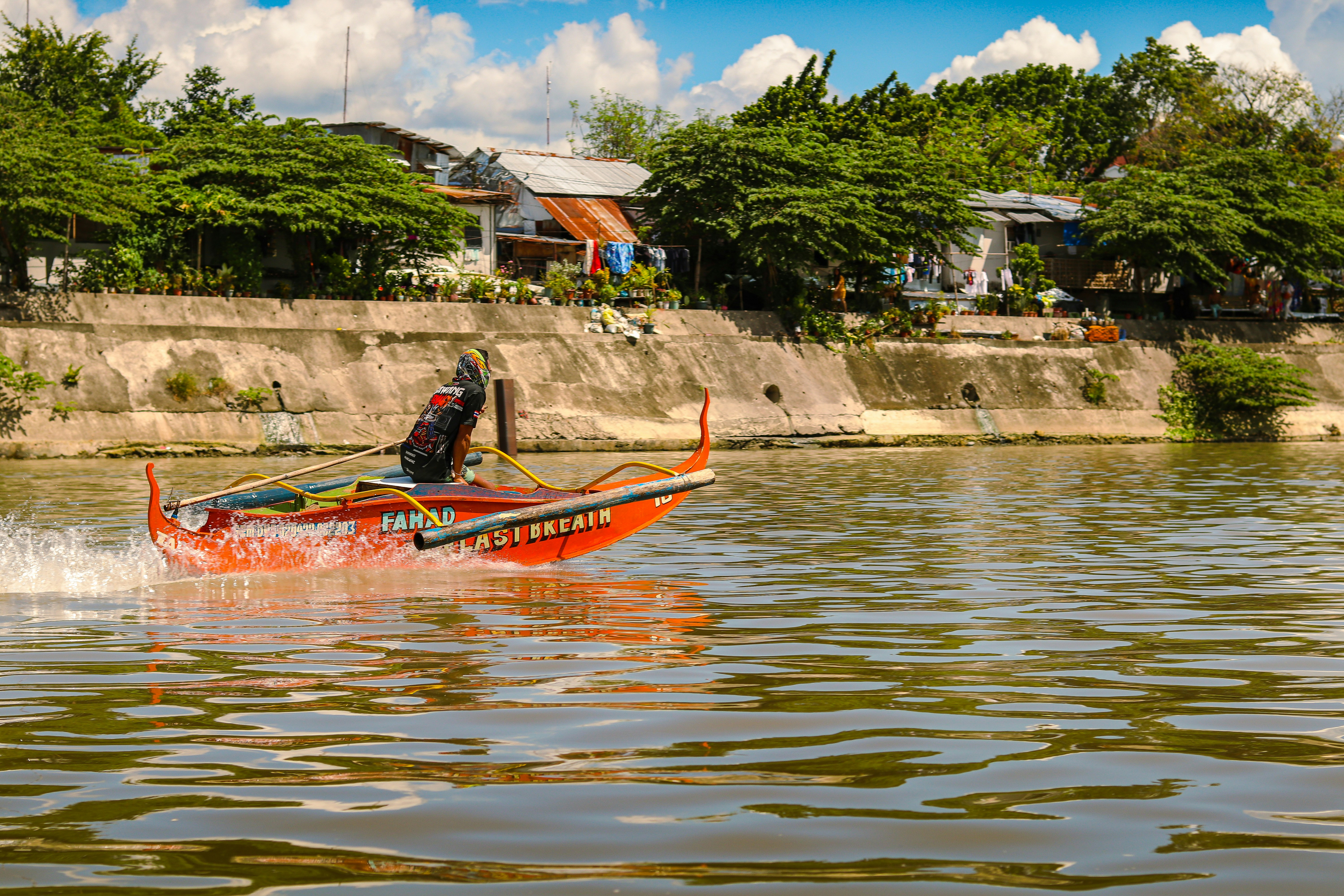 A man riding a boat on top of a lake photo – Free Purple Image on Unsplash
