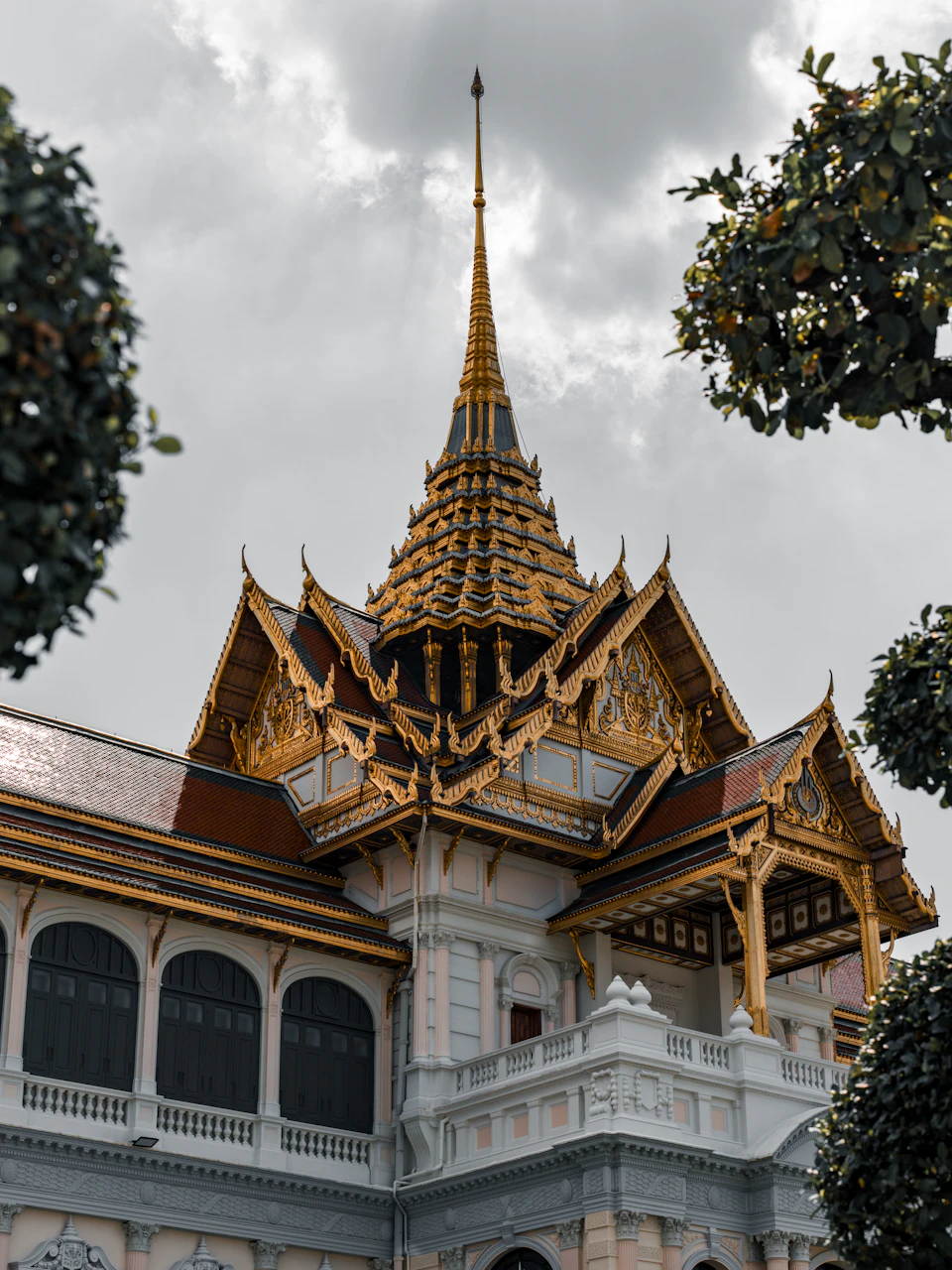 Majestic temple complex with golden spires amidst lush greenery and intricate stone carvings