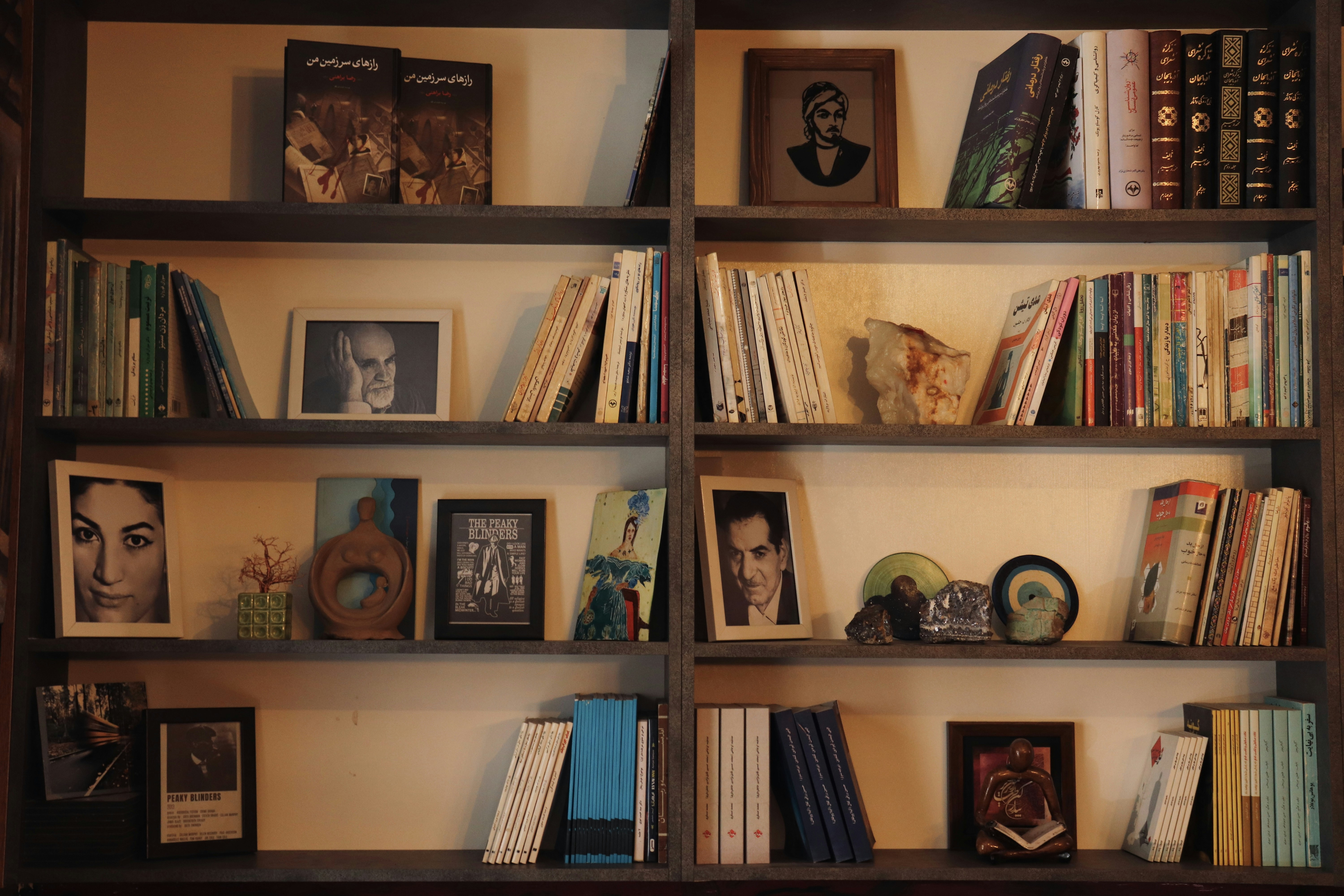 A bookshelf filled with lots of books next to a wall
