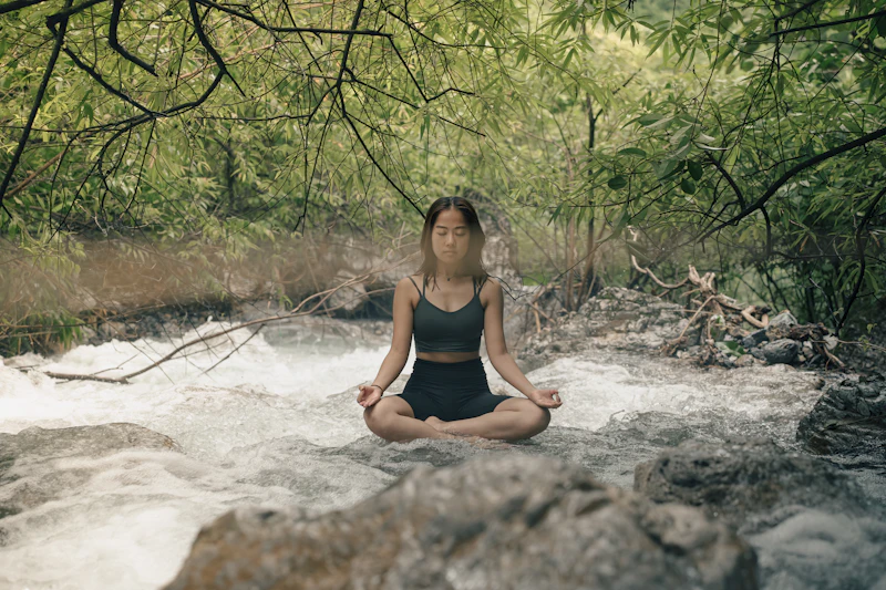 Woman meditating by a river