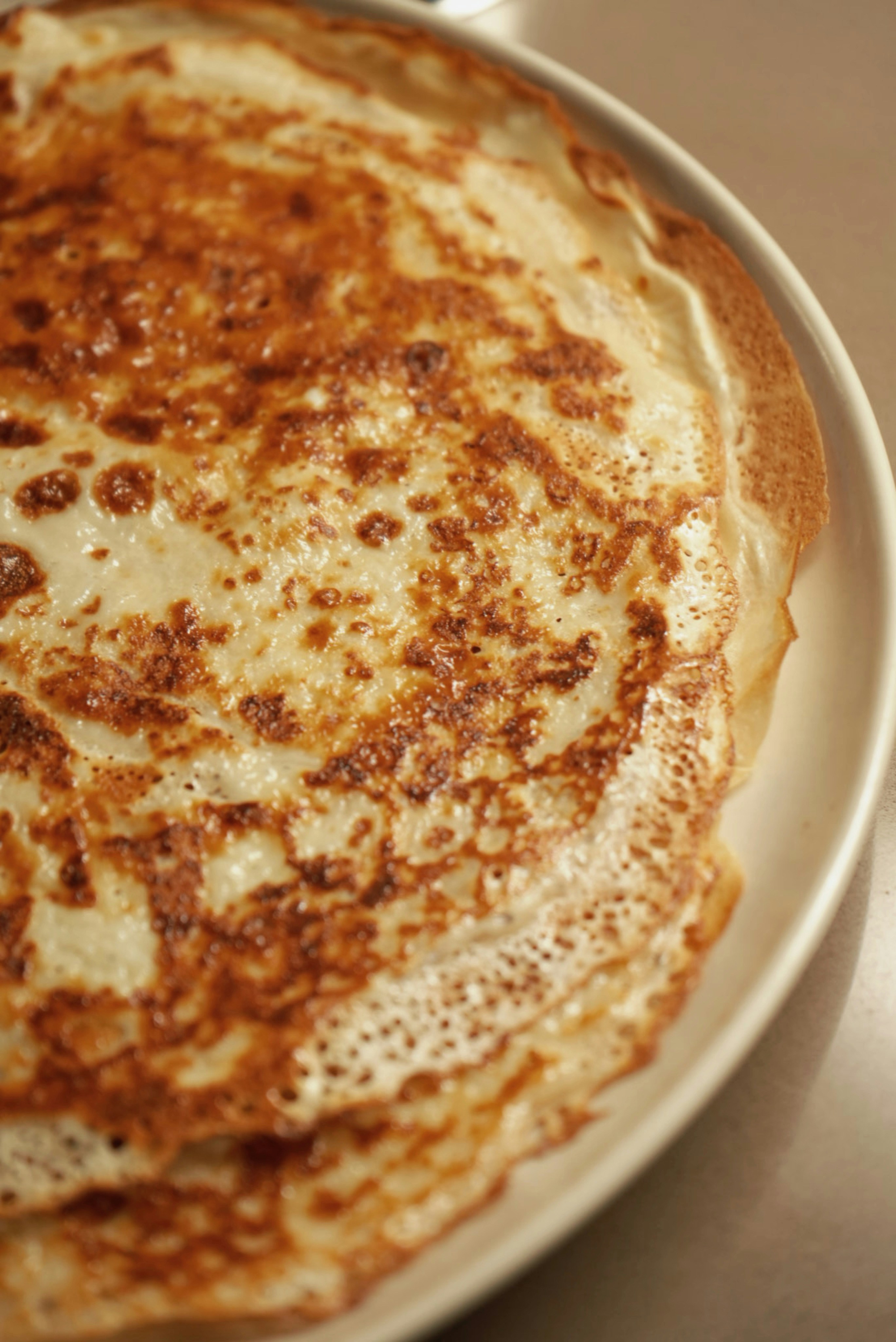 A white plate topped with pancakes on top of a table