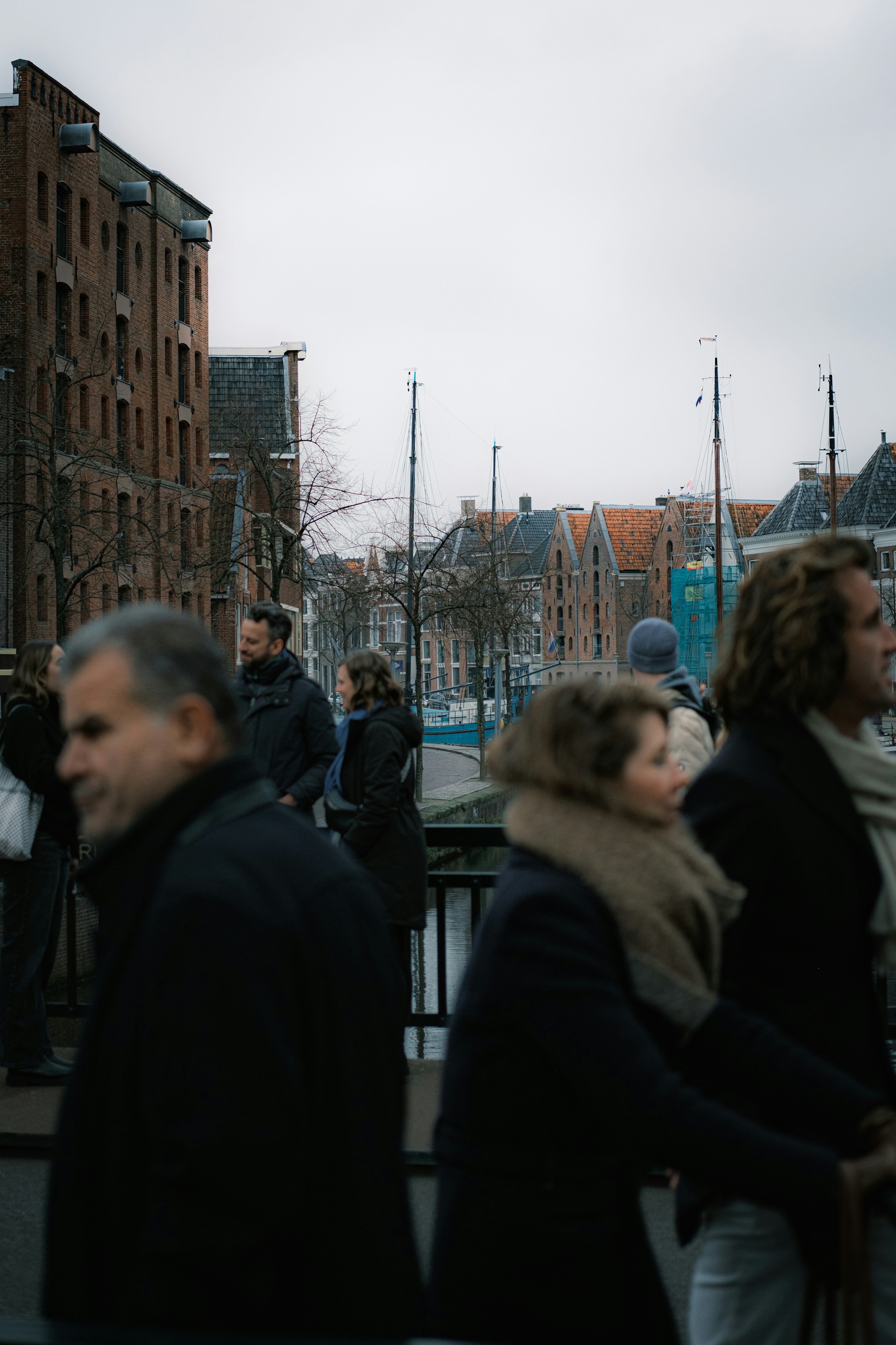 A group of people walking down a street next to tall buildings