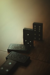 A pair of black dice sitting on top of a wooden table