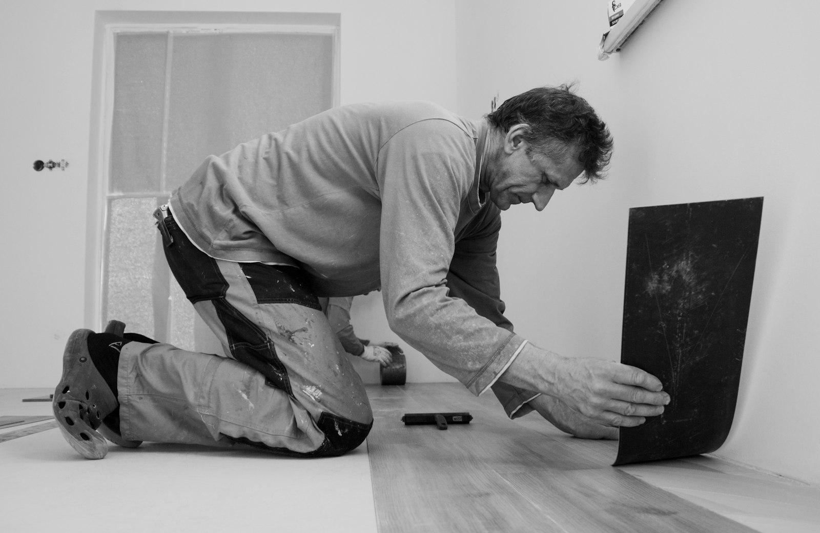 An installer fitting a floor plank