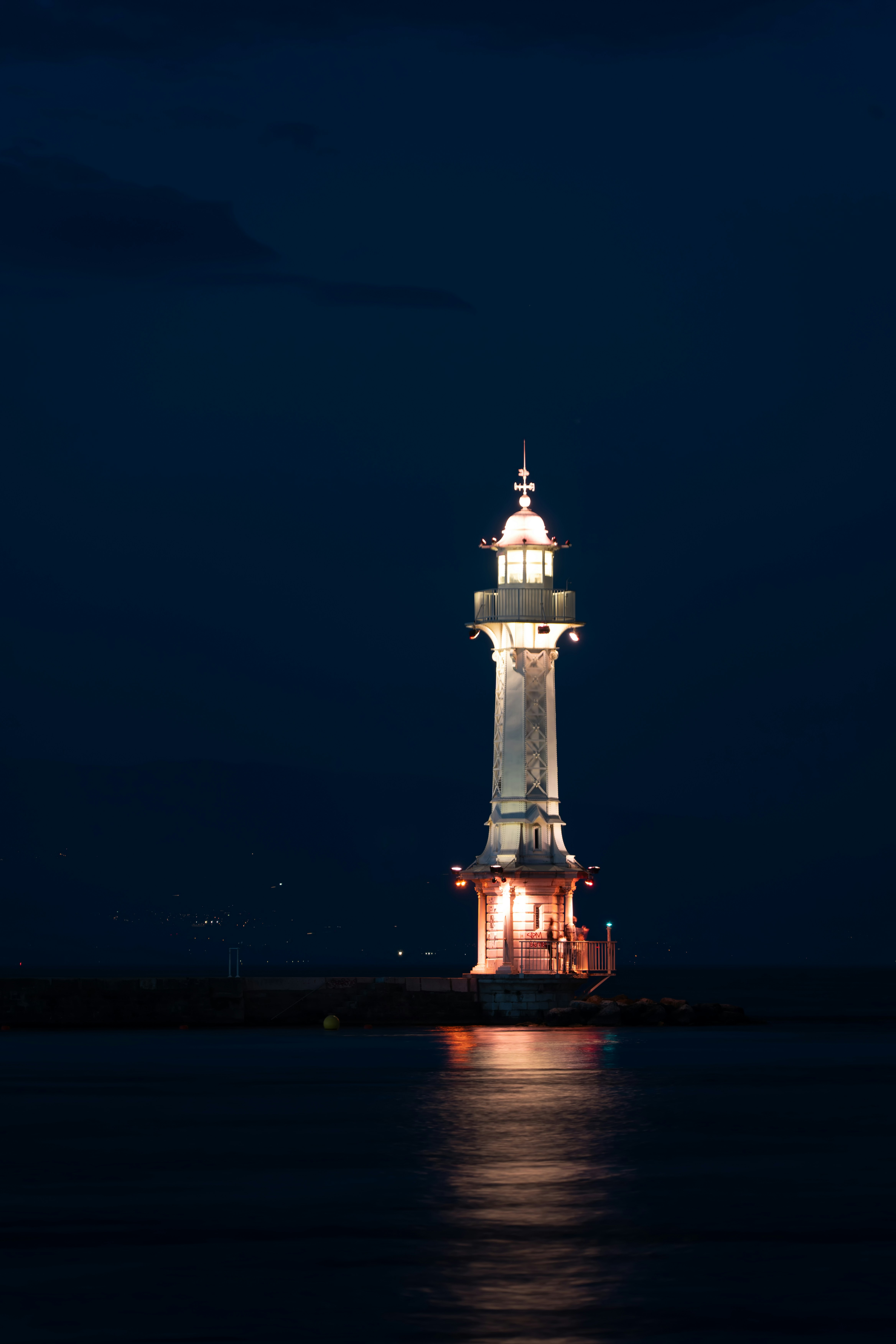 Un faro se ilumina por la noche en el agua
