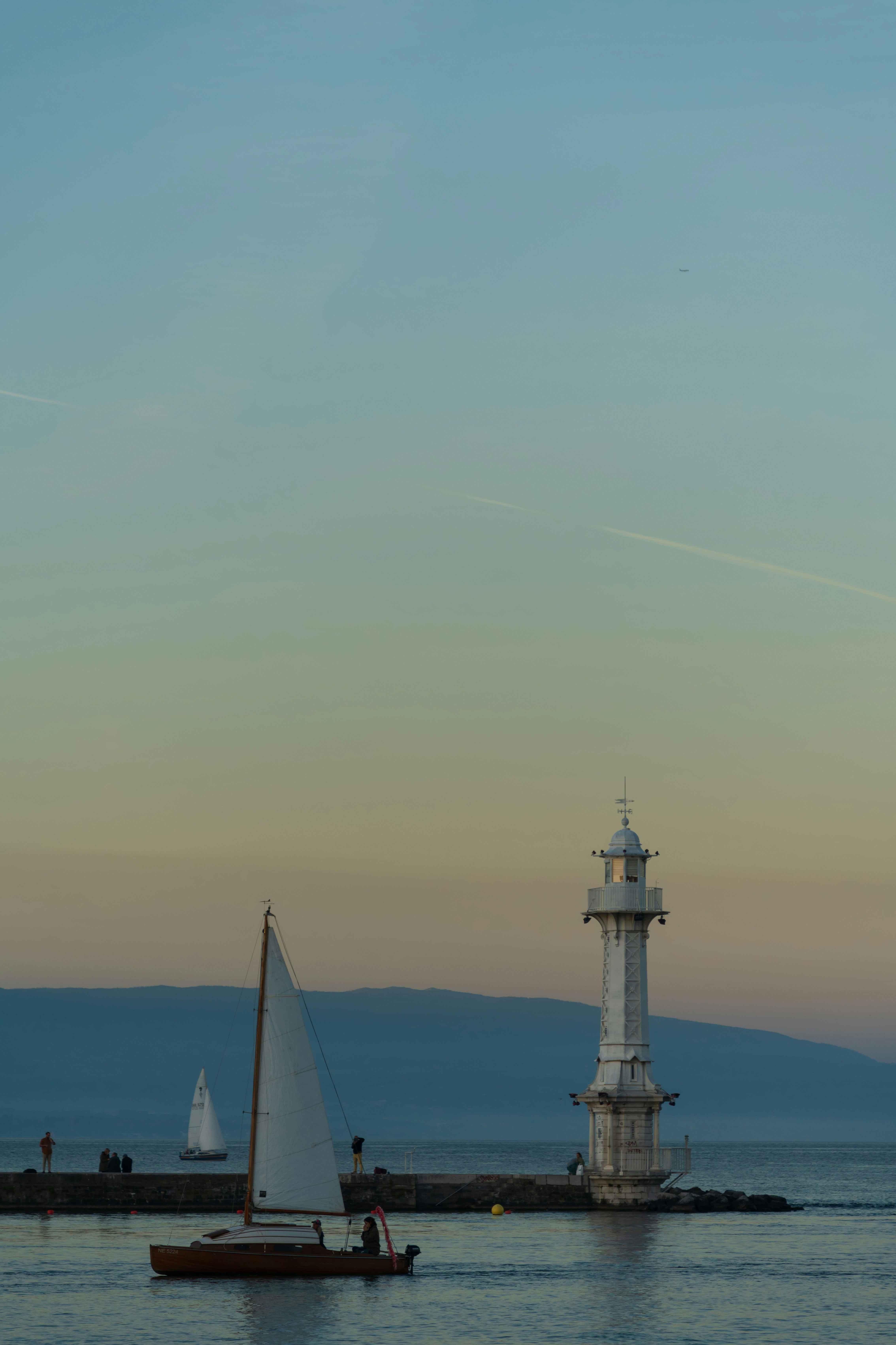 Un velero en el agua cerca de un faro