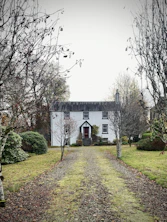 A white house surrounded by trees and bushes