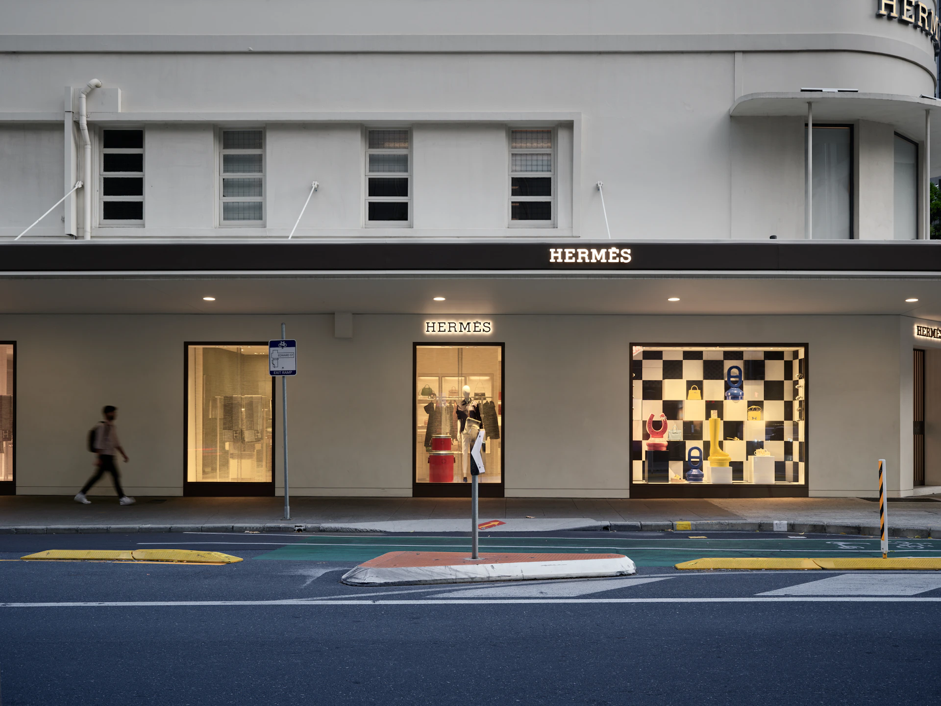 A person walking past a building with a checkerboard design on it