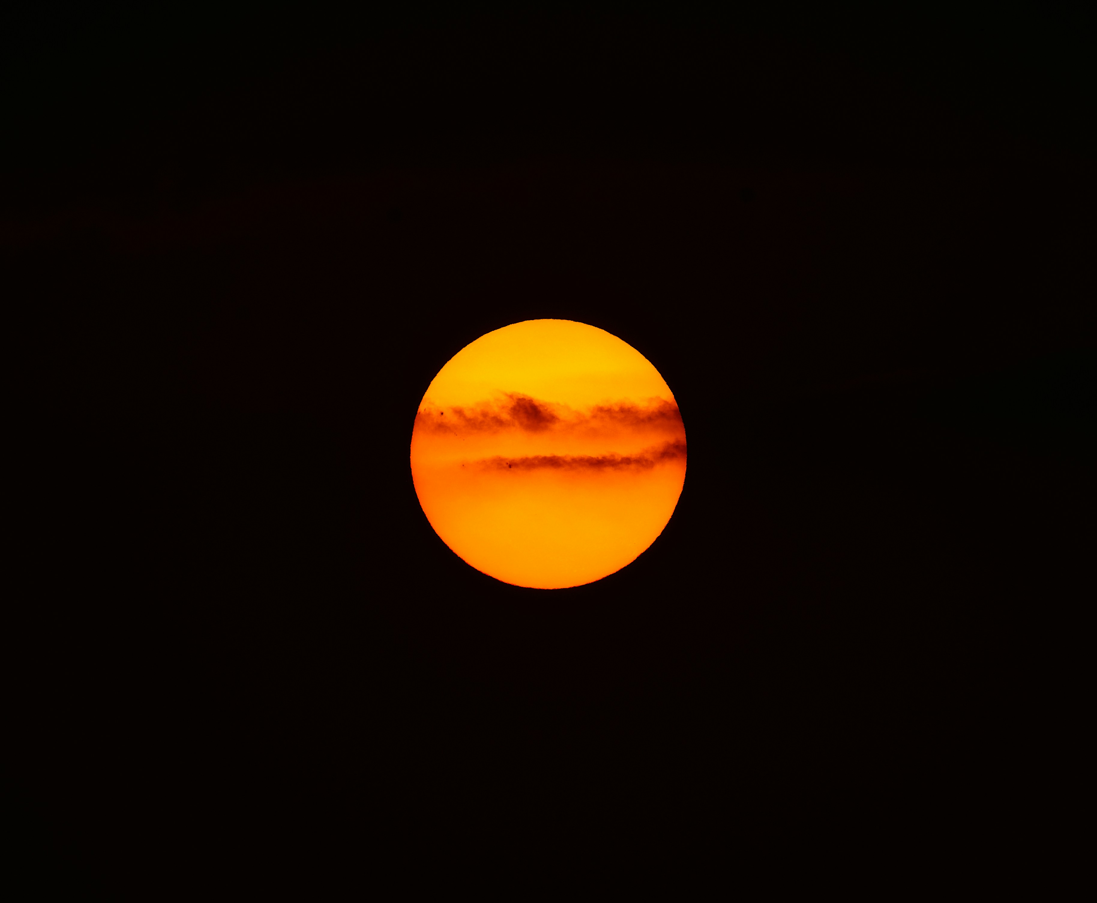 The sun is setting in the dark sky