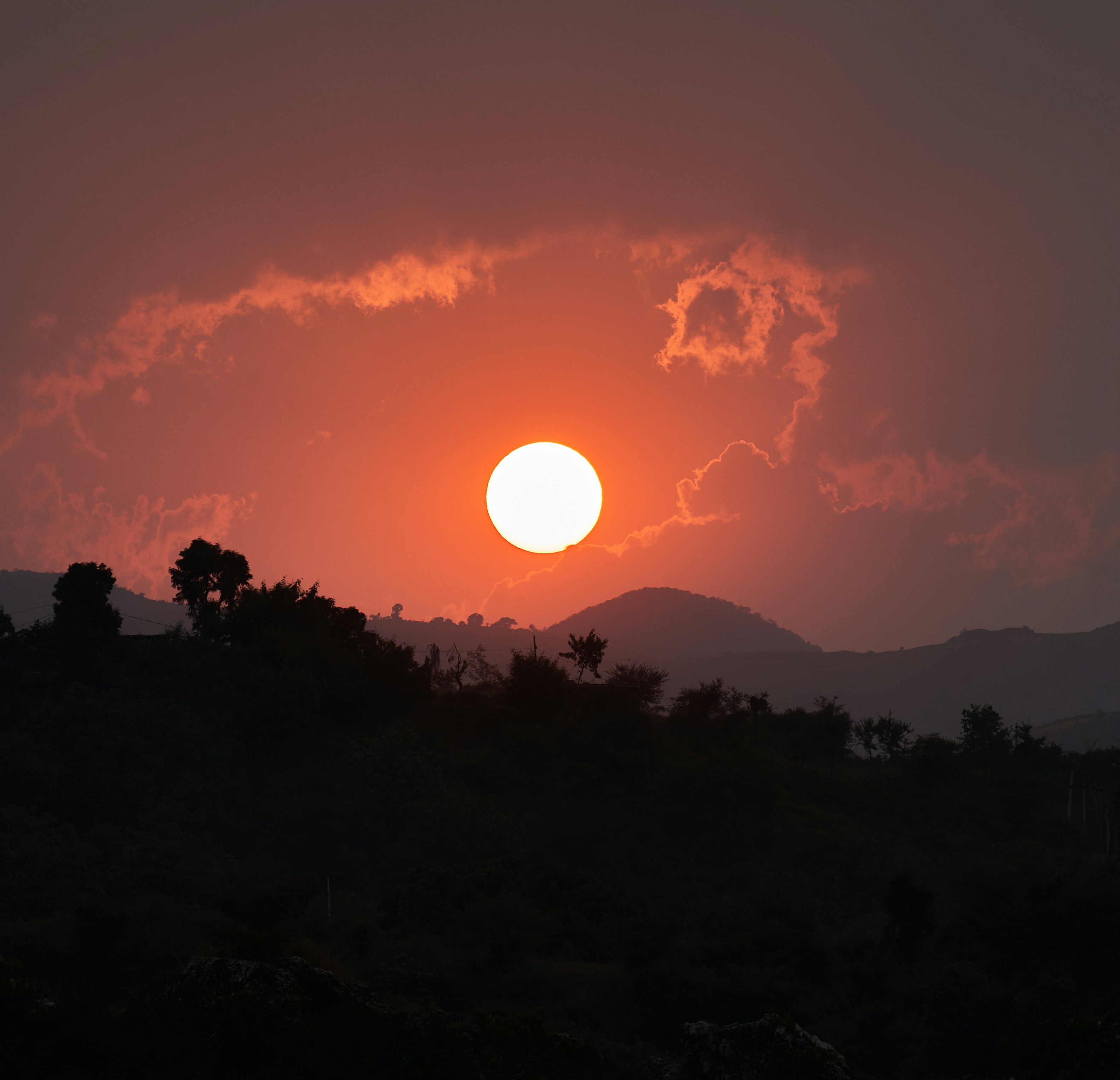 The sun is setting over a mountain range