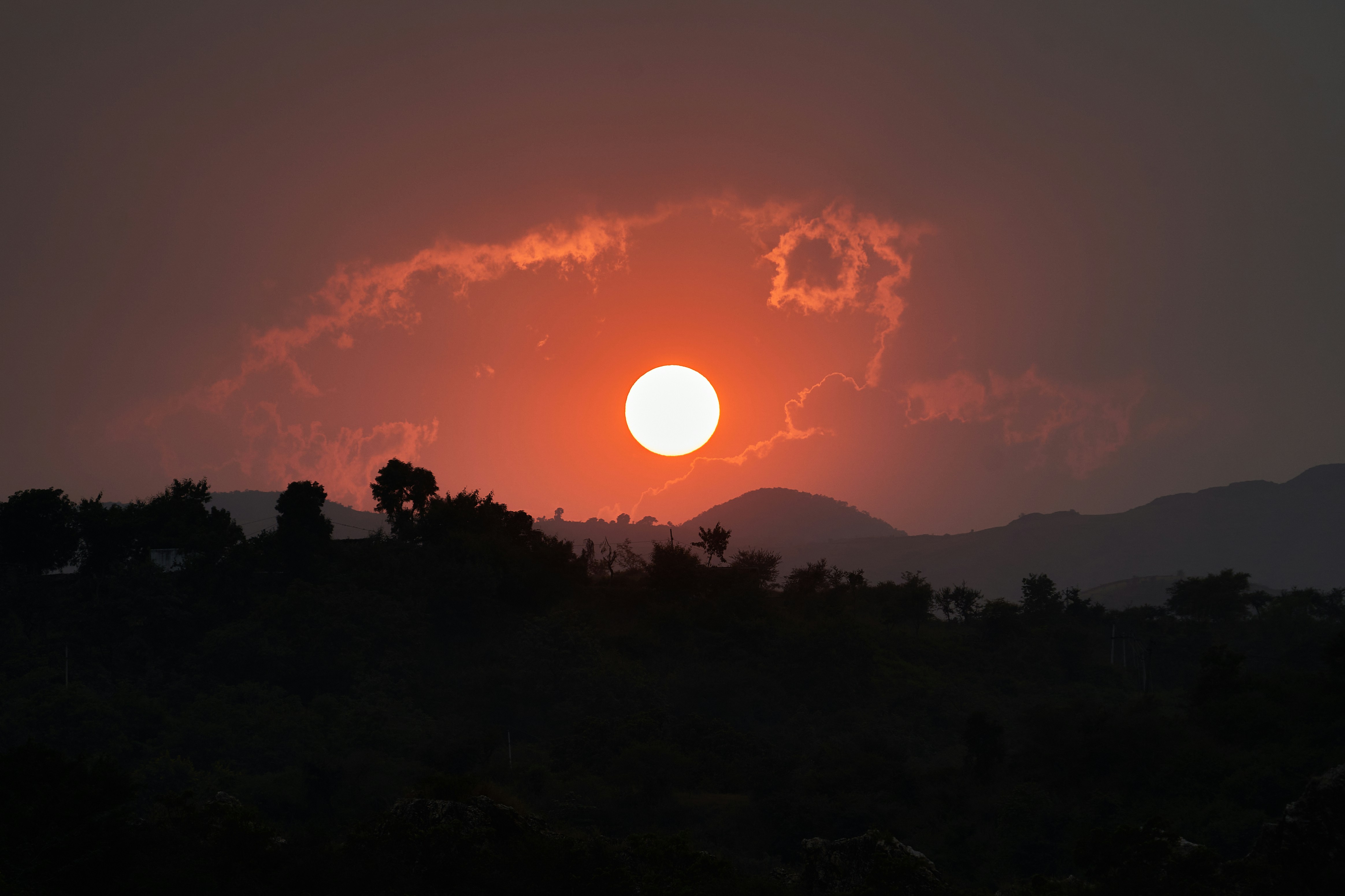 The sun is setting over the mountains in the distance