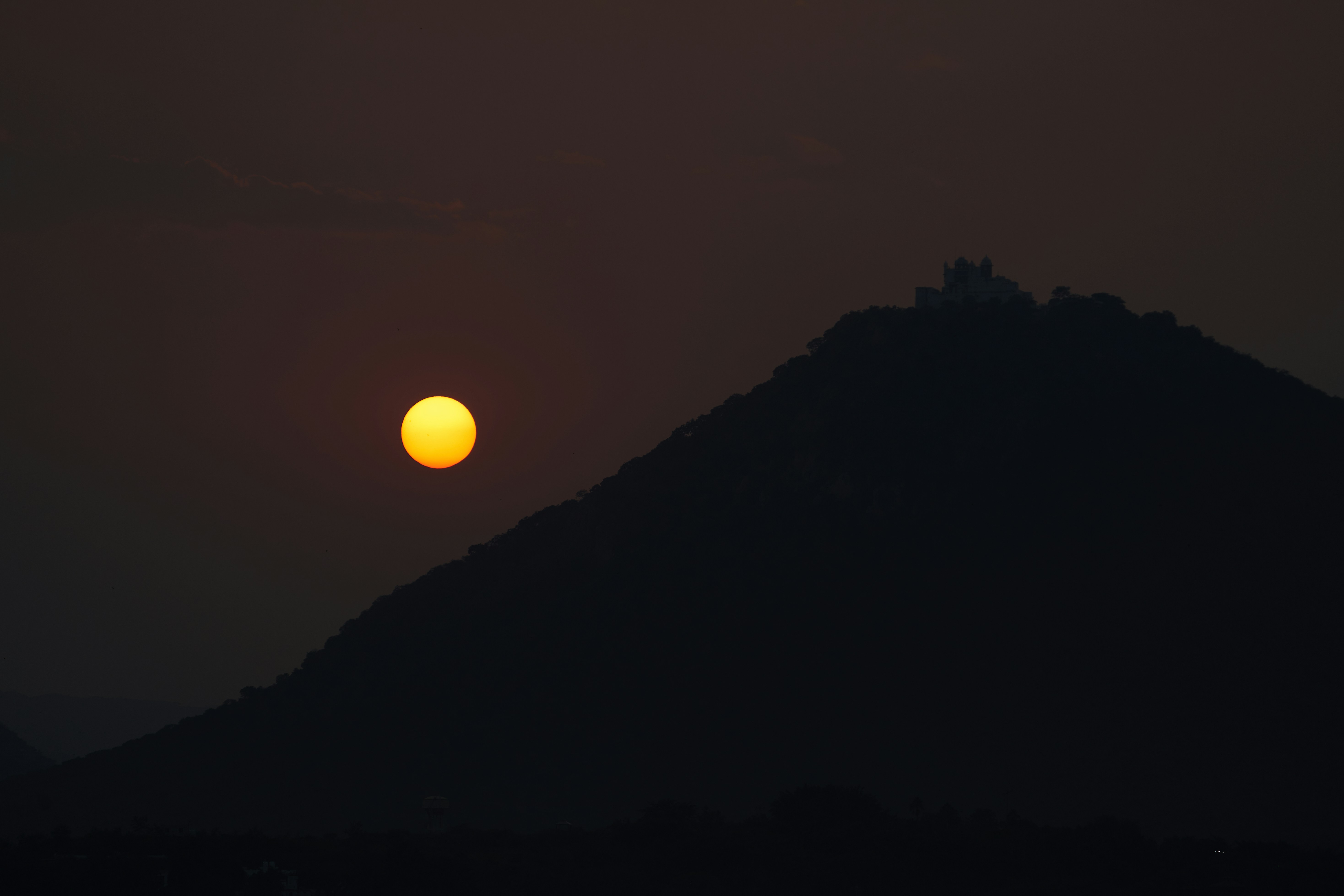 The sun is setting behind a mountain