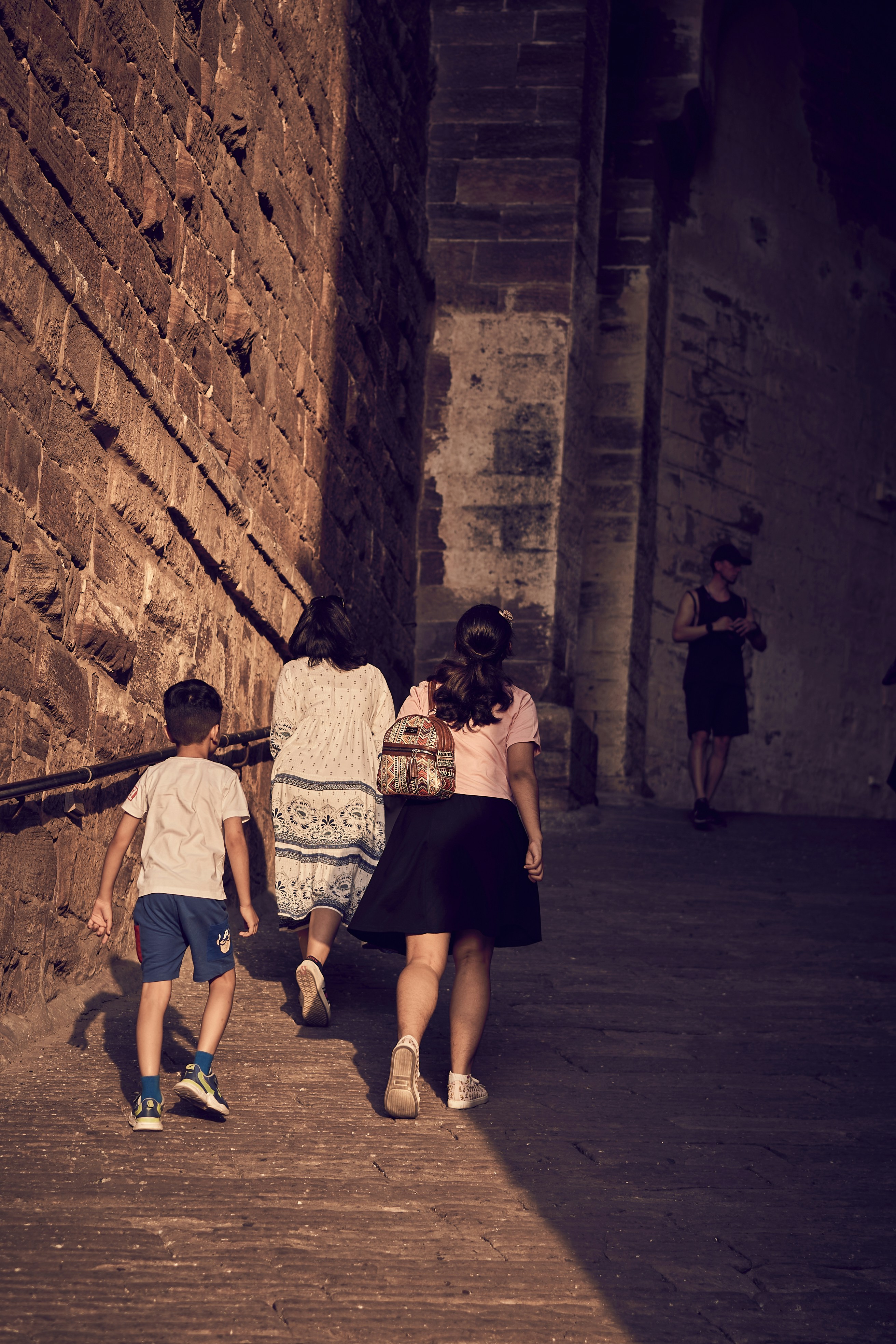 A woman and two children walking down a street