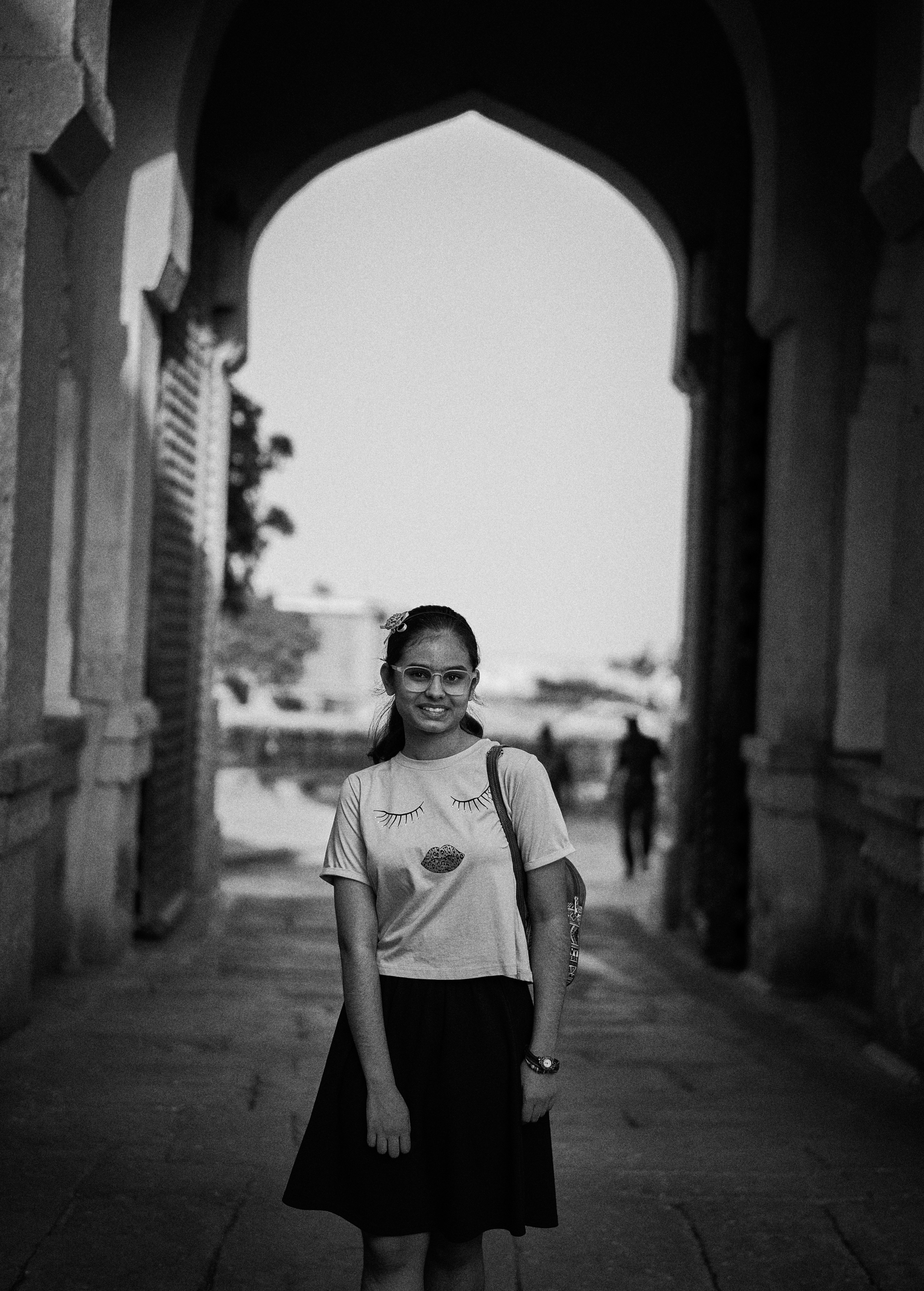 A woman standing in an archway with a smile on her face