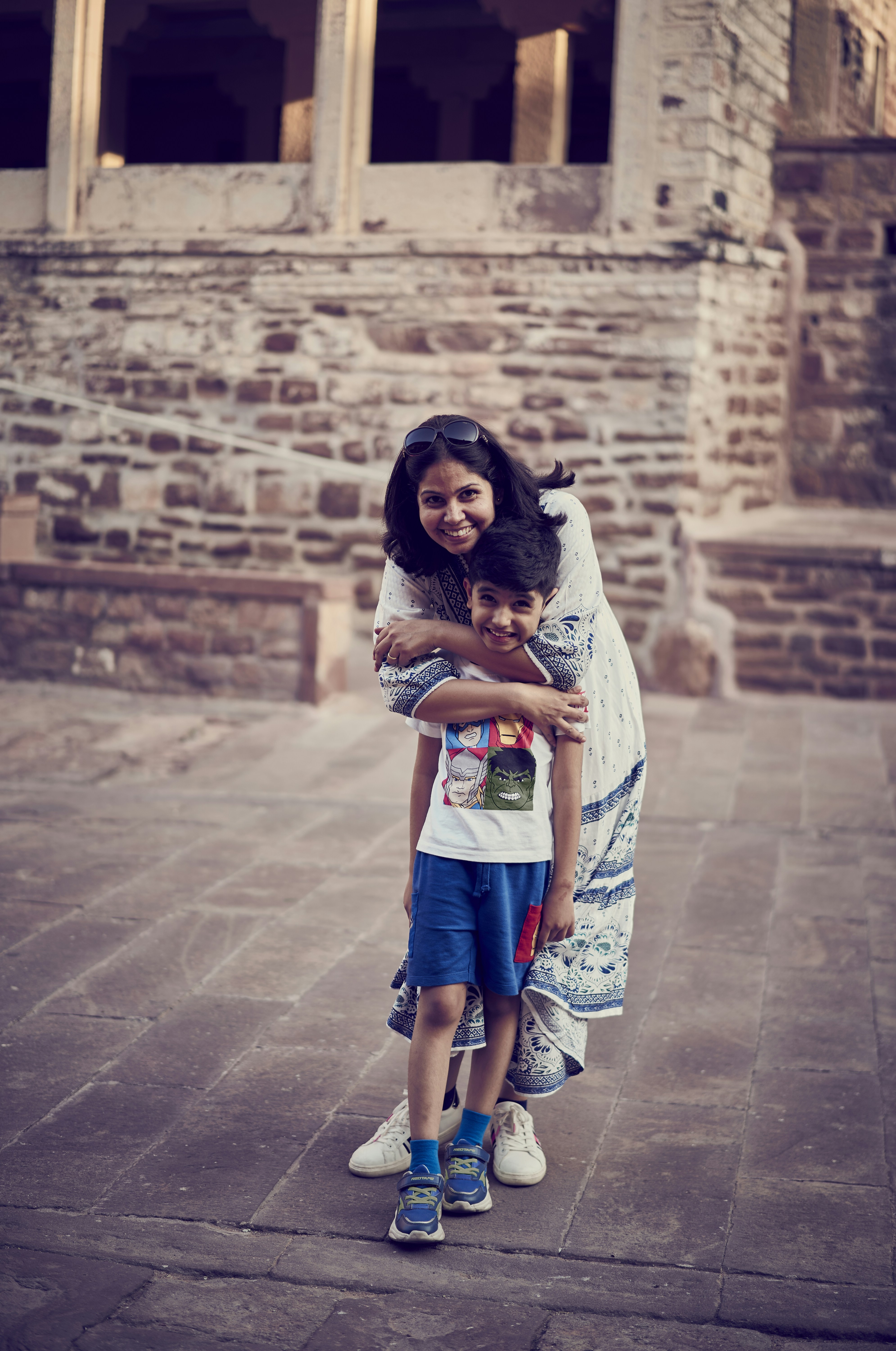 A woman and a child standing in front of a building
