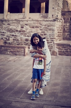 A woman and a child standing in front of a building