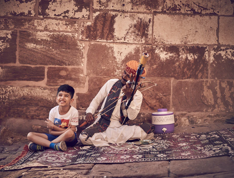 An Indian father and son sitting together on a rug, bonding during a session