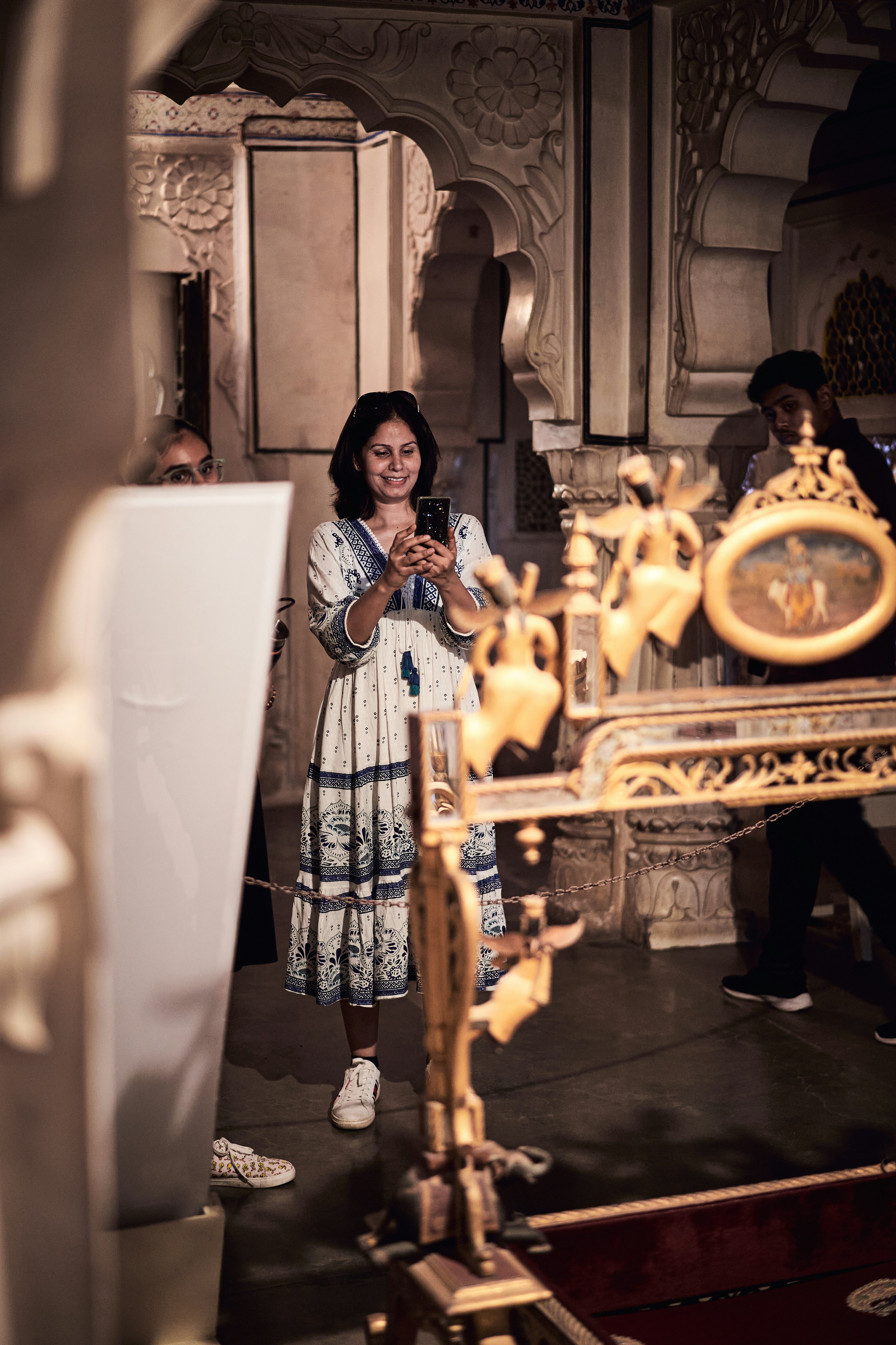 A woman standing in front of a golden clock