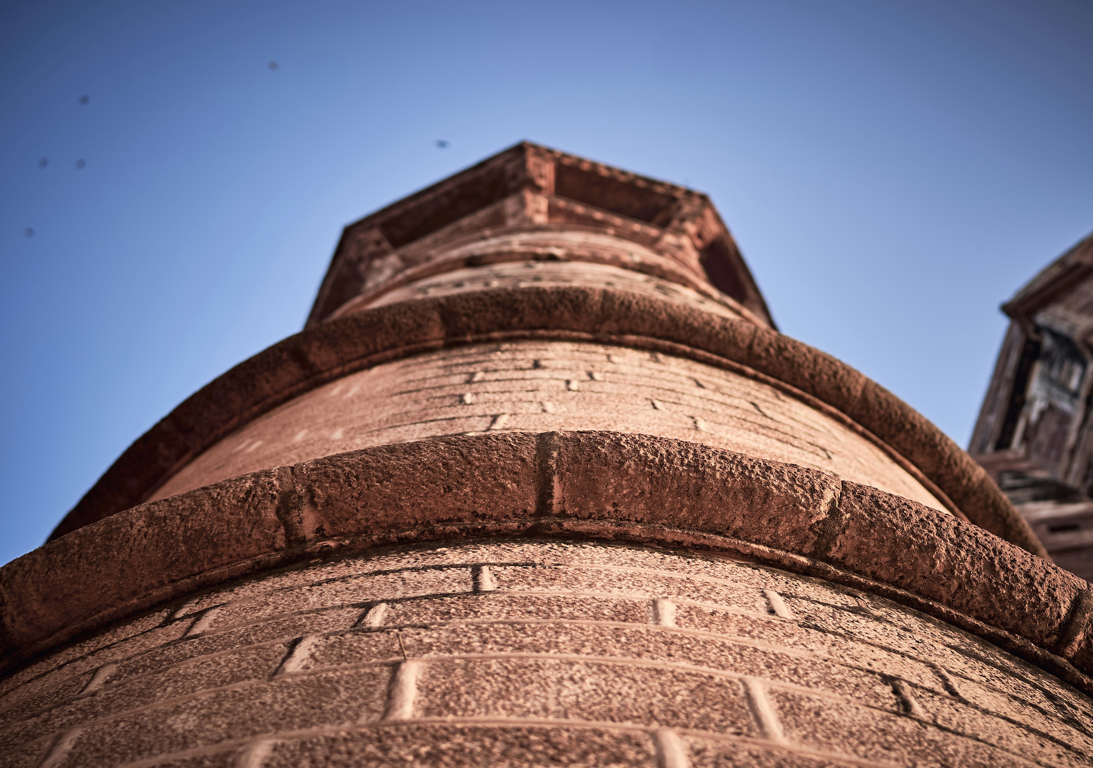A tall brick tower with a clock on it's side
