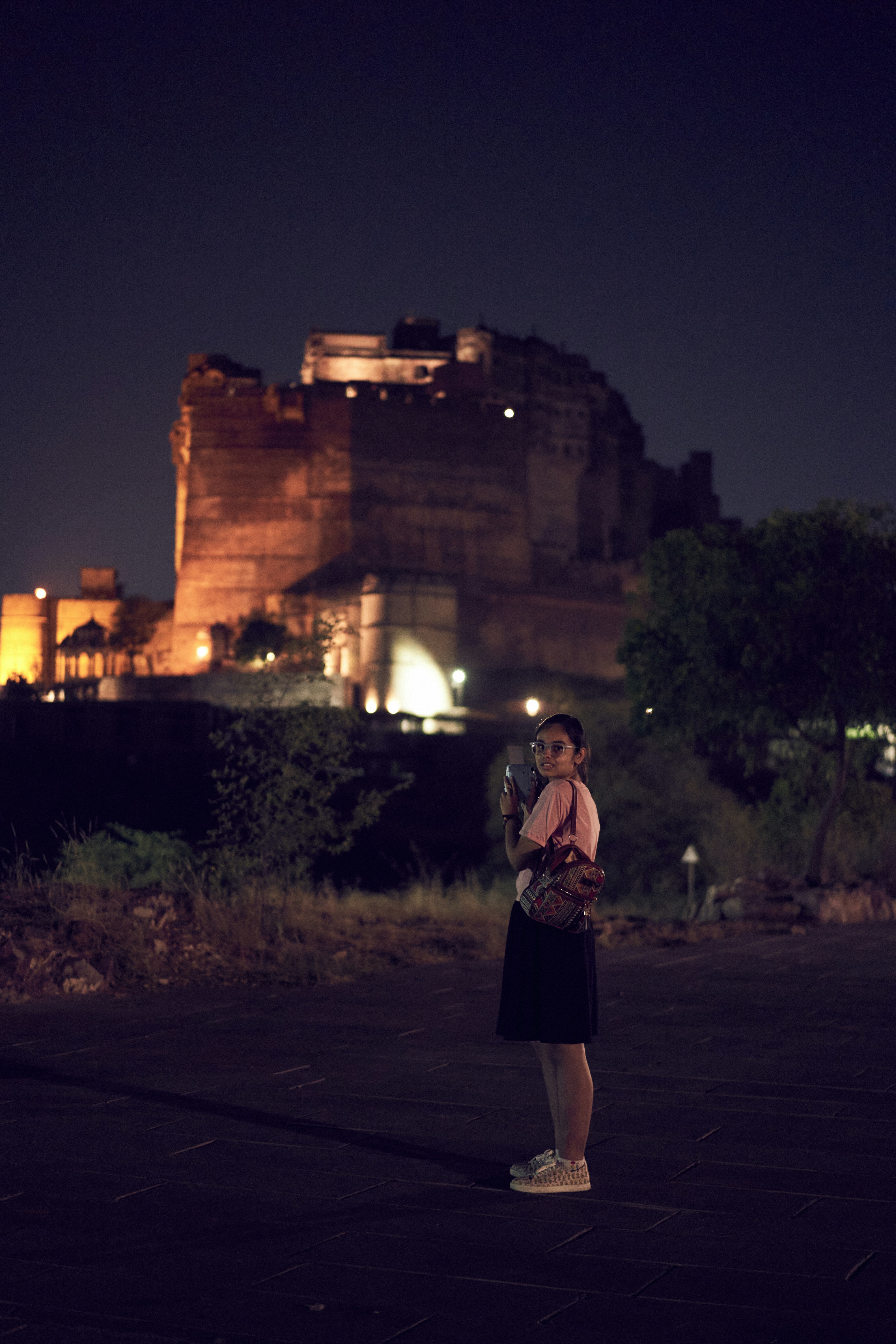 A man standing in front of a castle at night