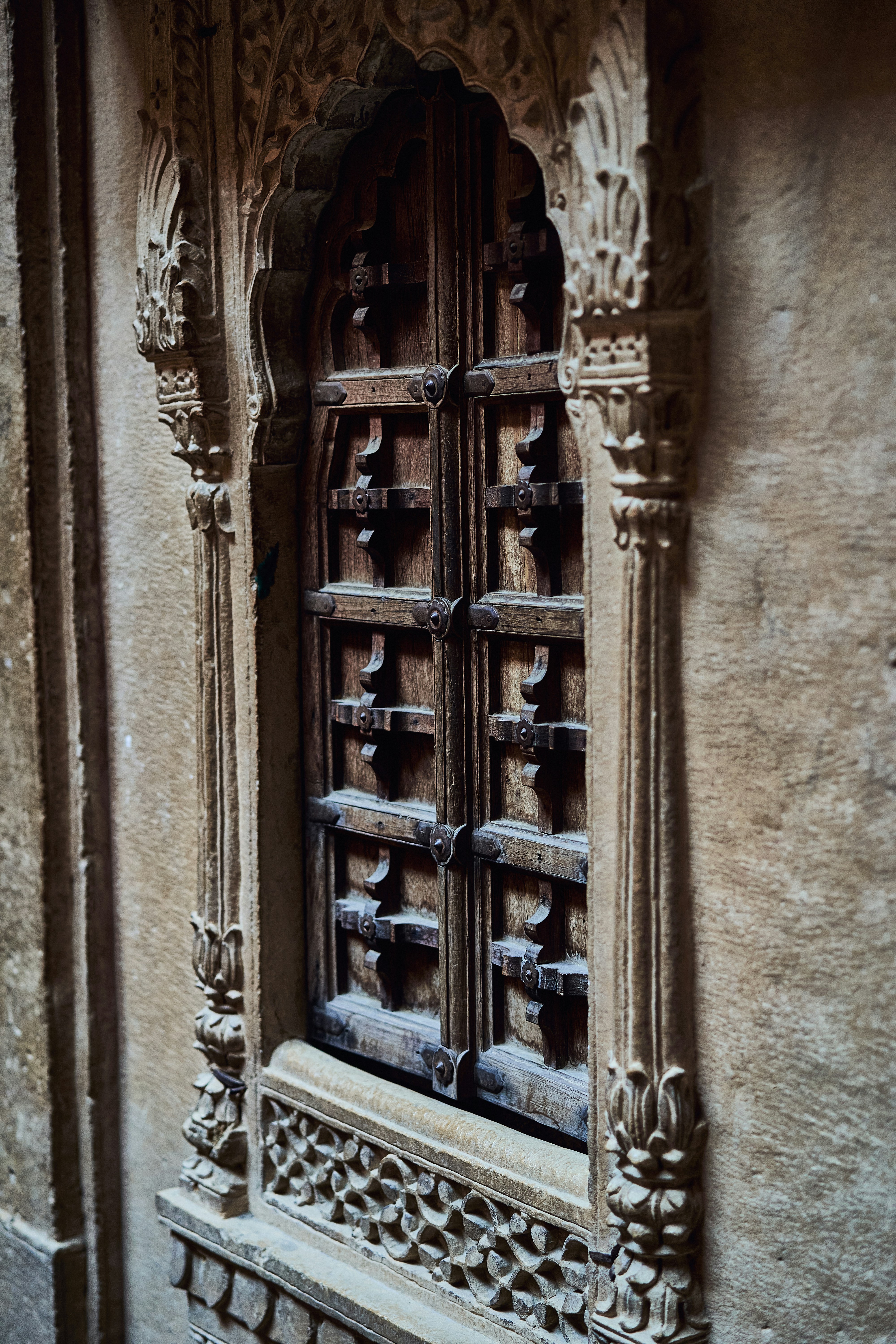 A carved wooden door on the side of a building