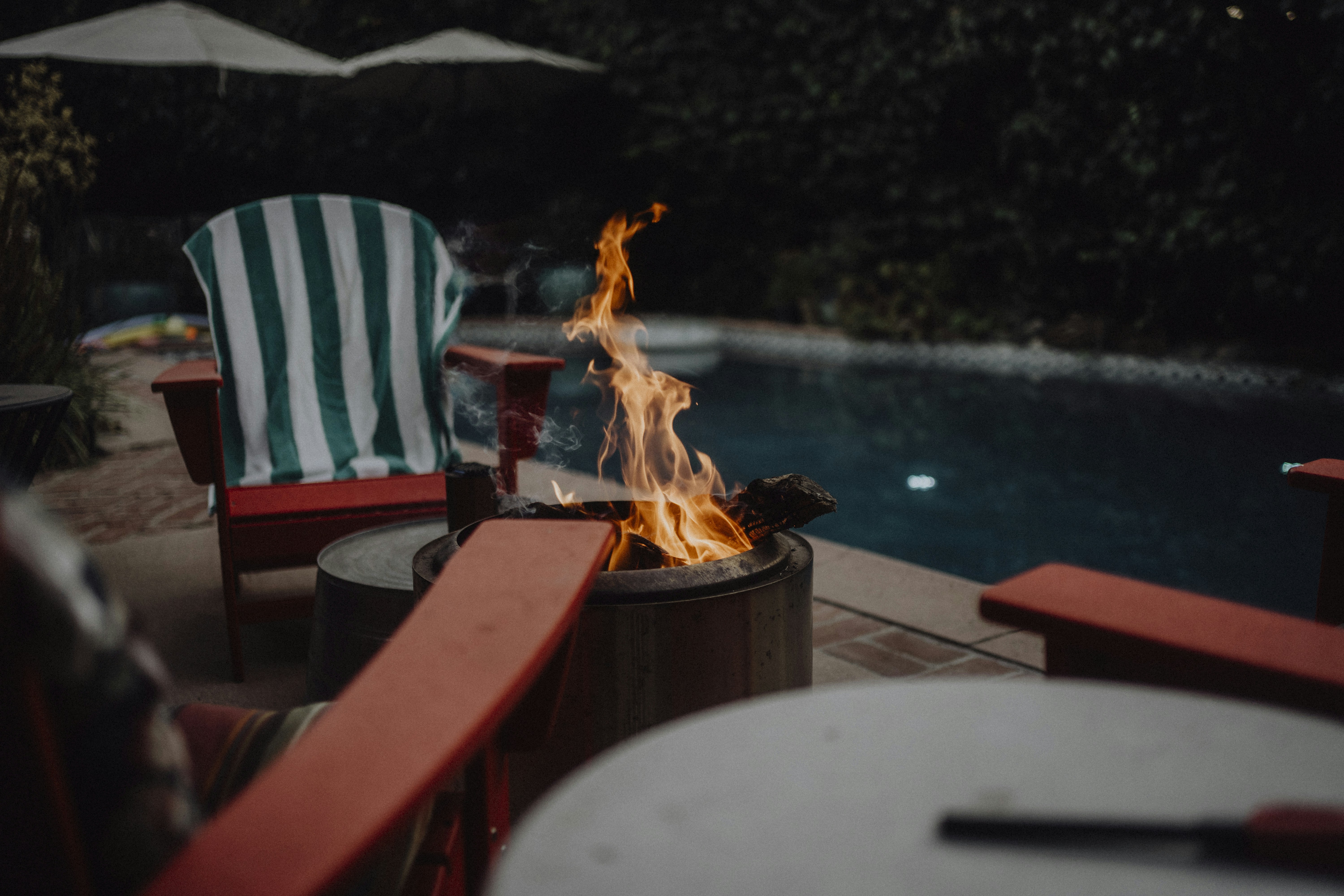 A fire pit sitting next to a swimming pool